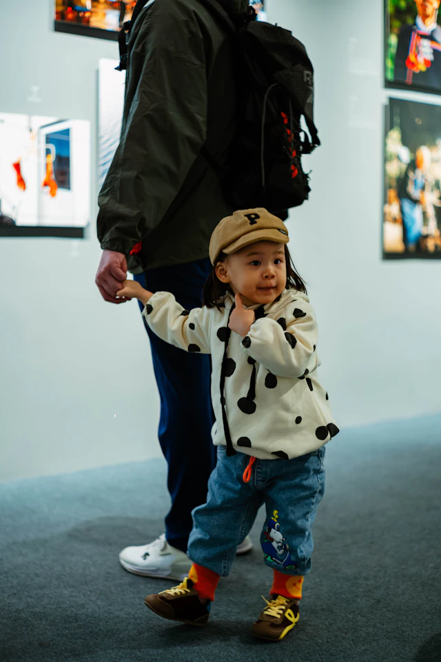 Kind aan de hand van een volwassene op een tentoonstelling
