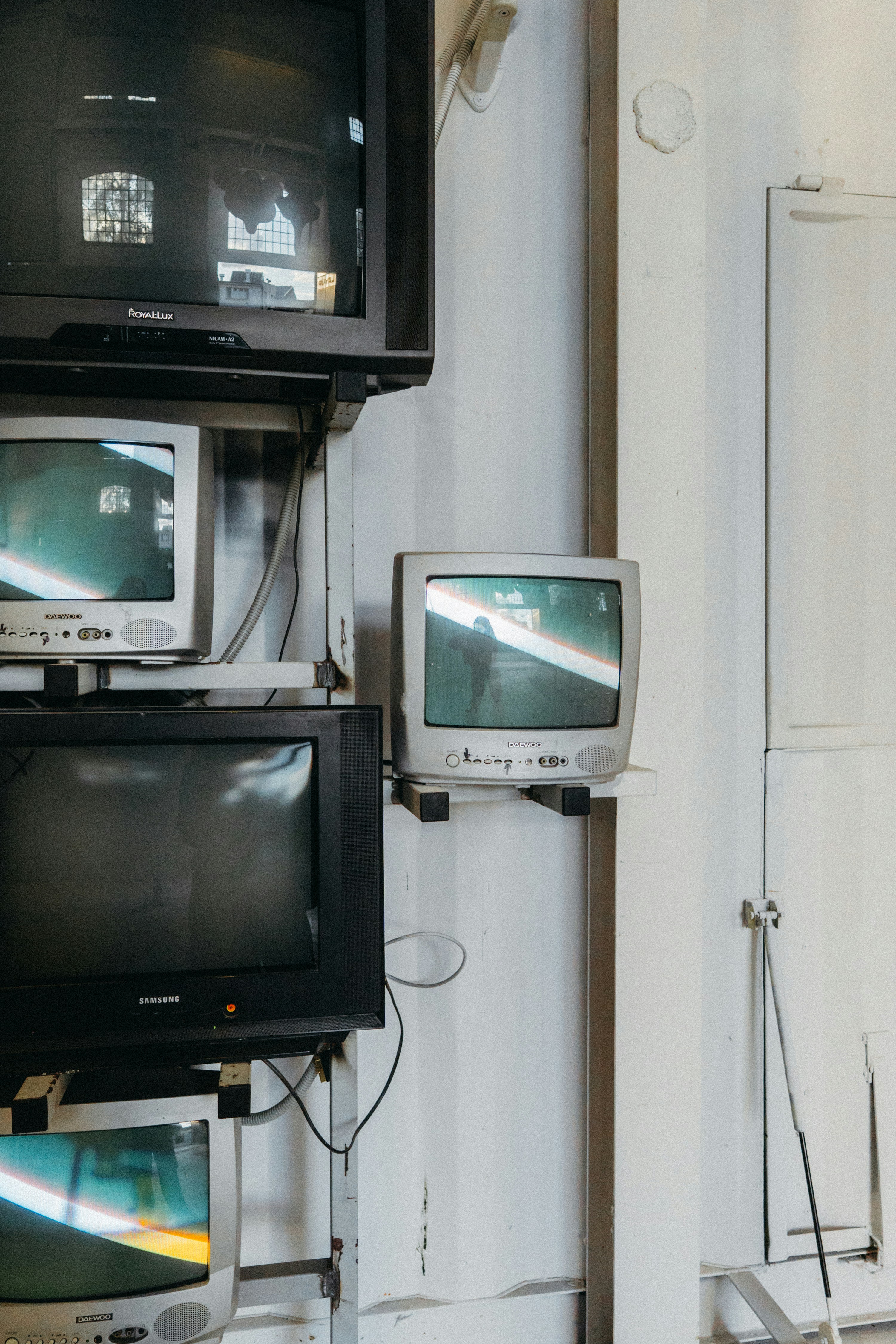 Stack of old televisions on a white wall