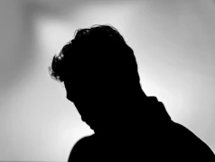 Silhouette of a person looking down