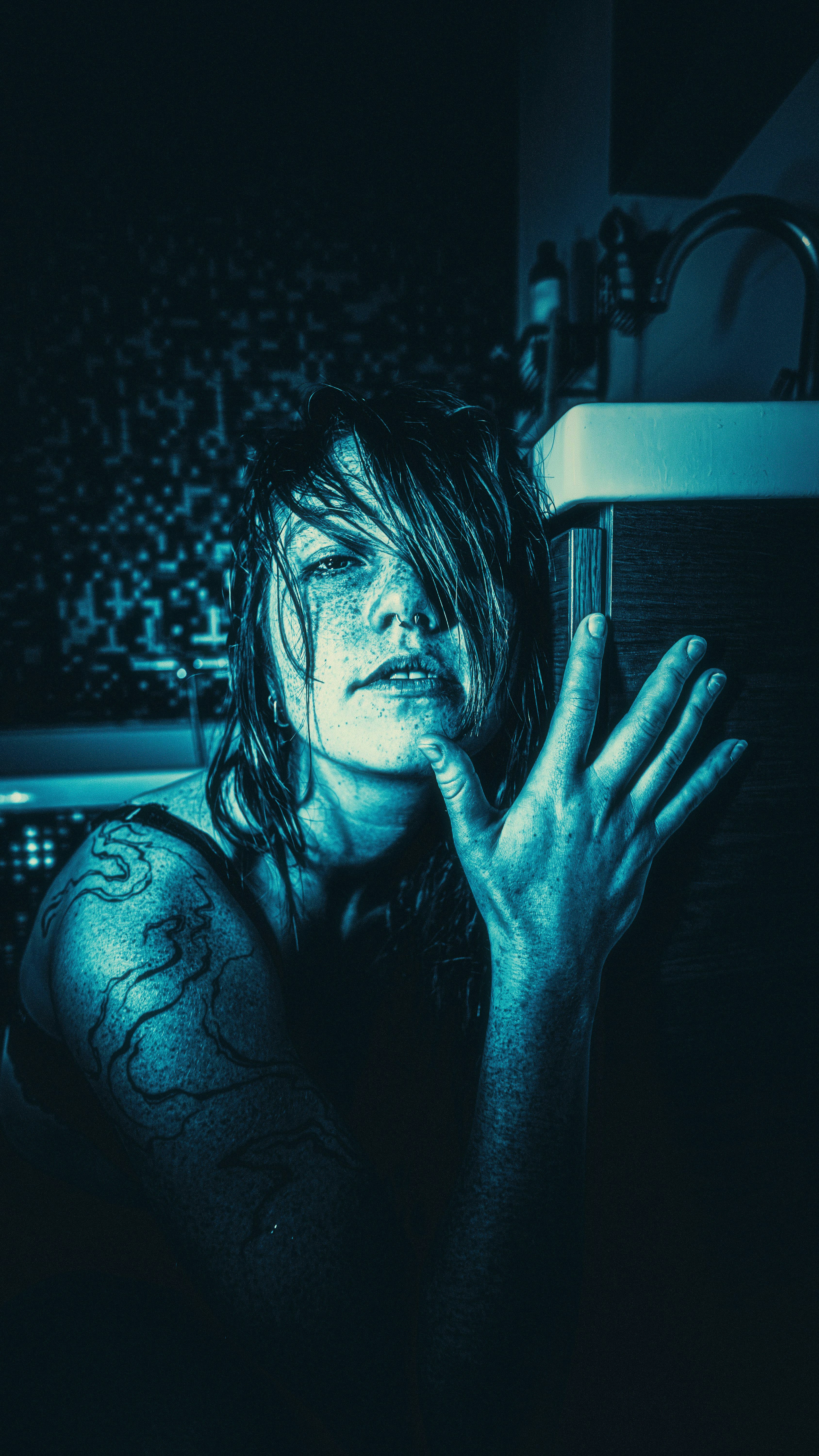 Woman with wet hair and tattoos in bathroom