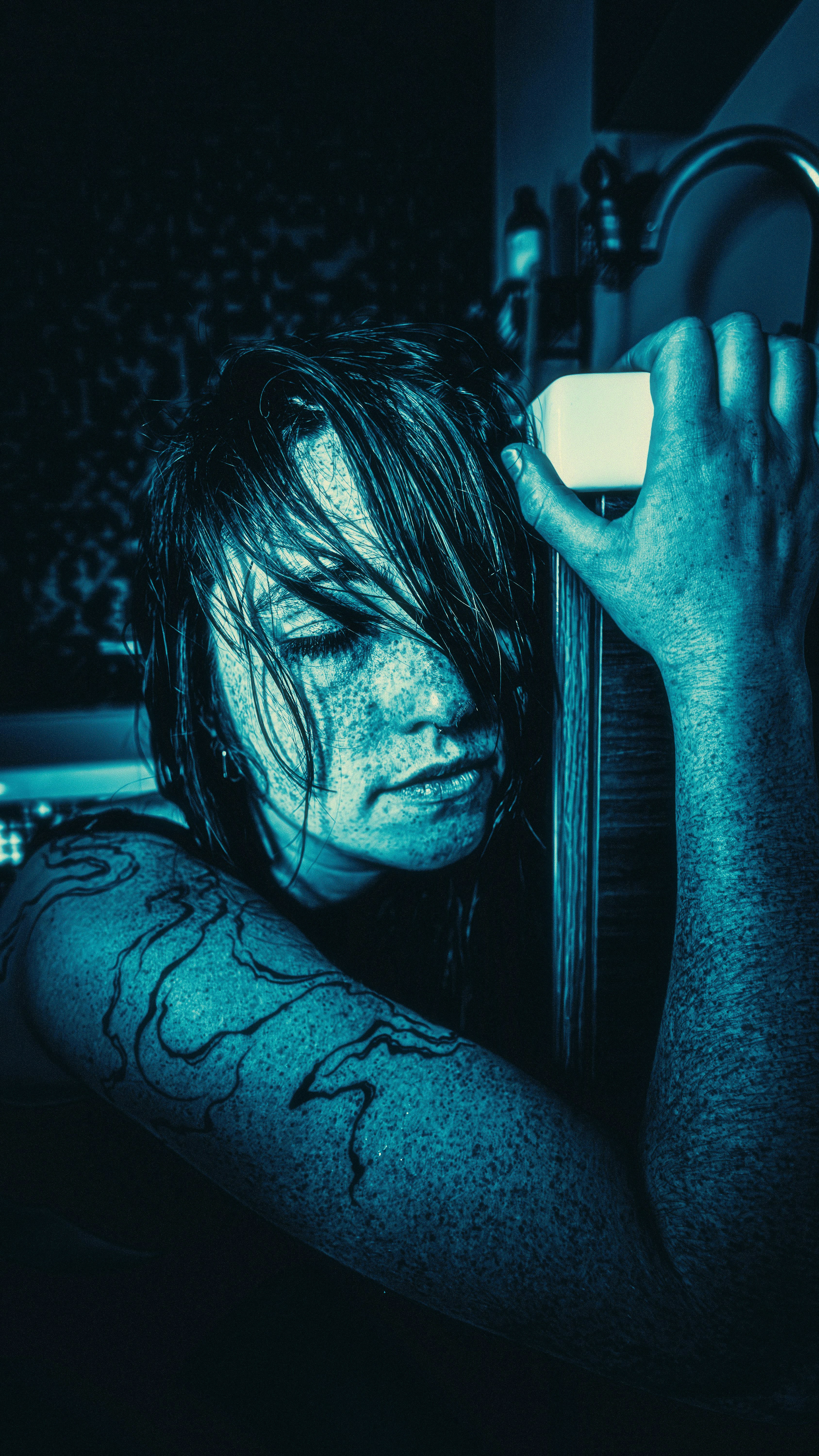 Frau mit nassen Haaren, die Seife in der Dusche hält