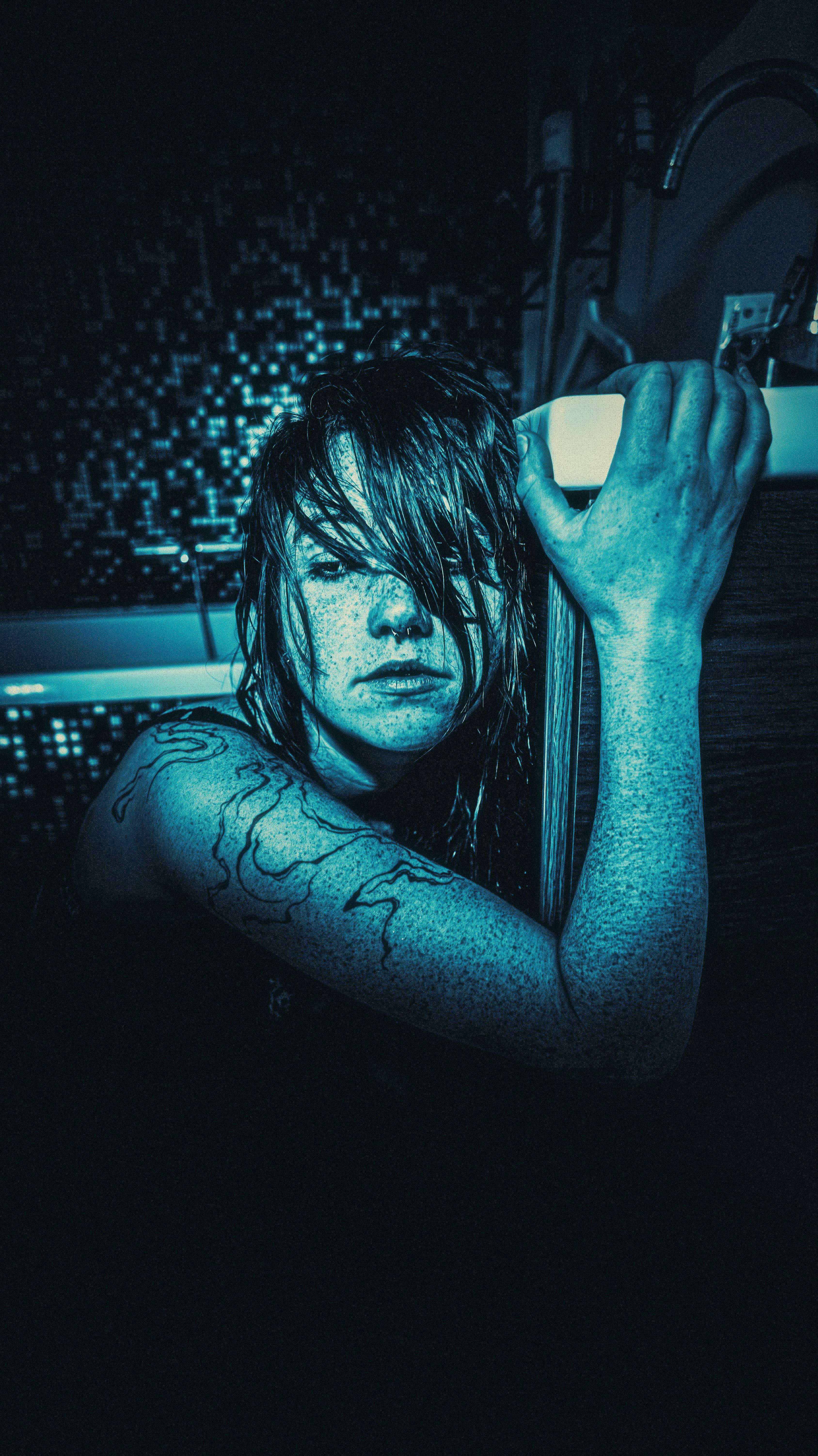 Woman with wet hair holding onto bathtub edge