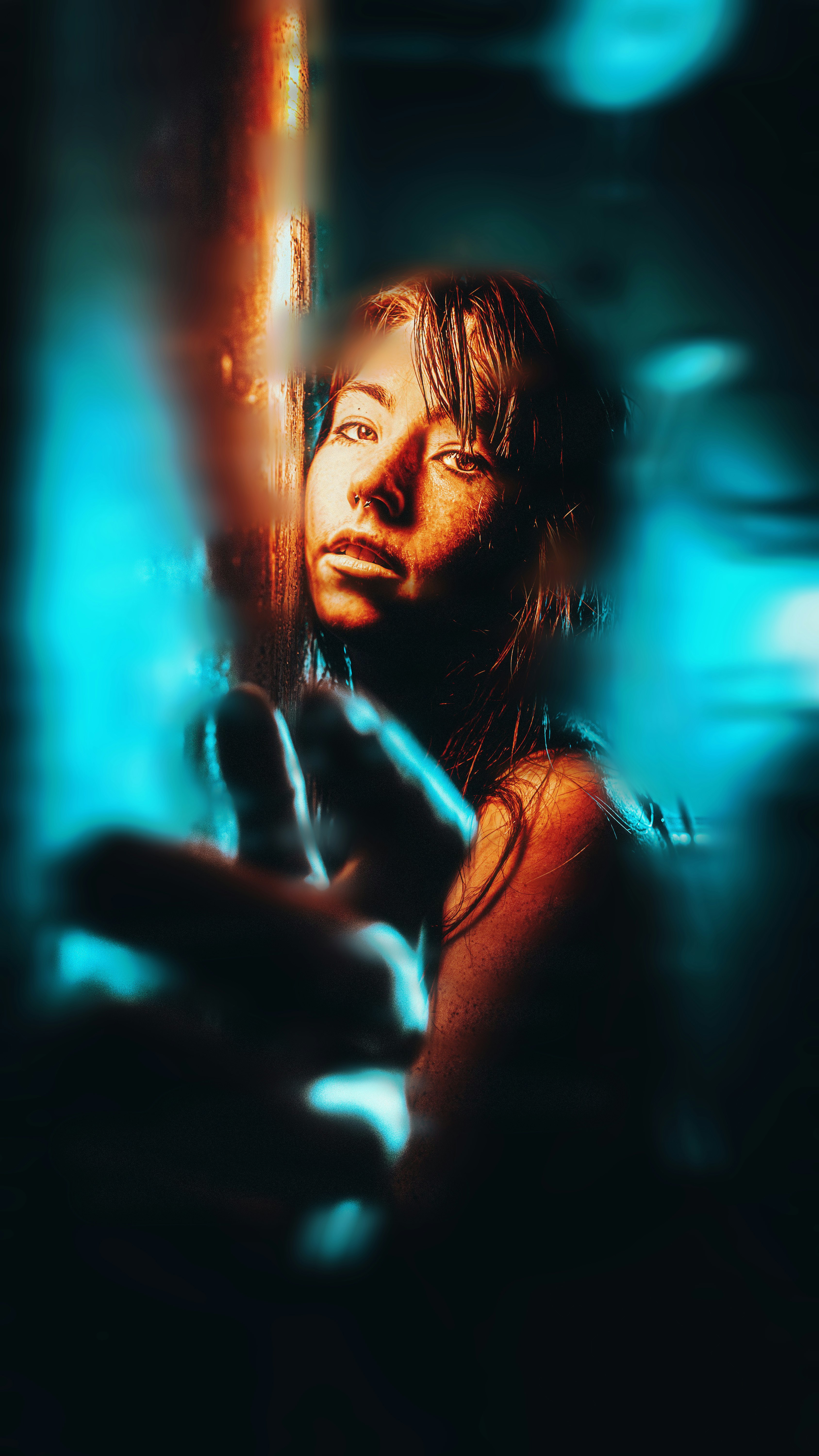 Woman reaching out with neon blue and orange light