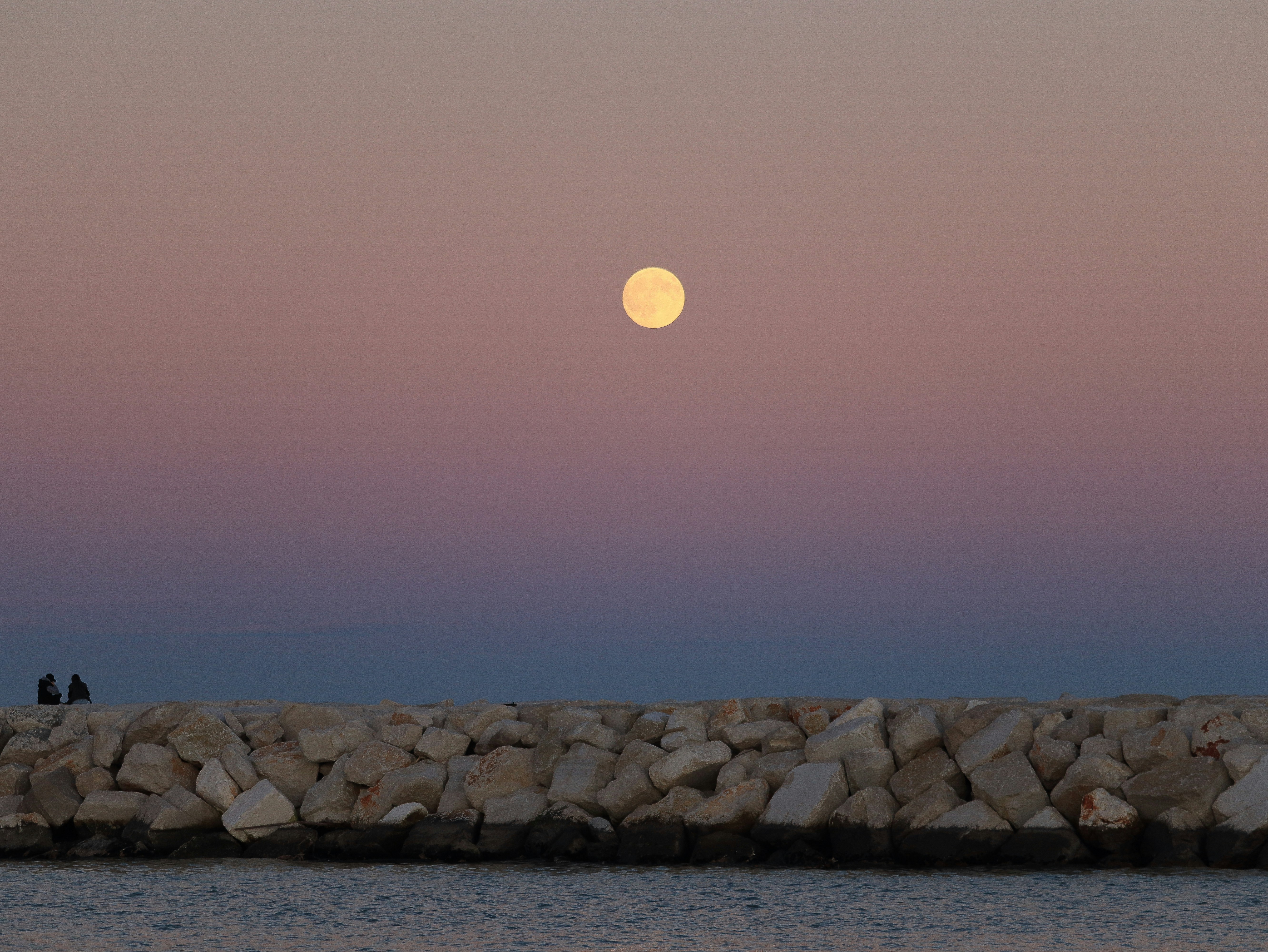 full moon rising over ocean horizon night sky