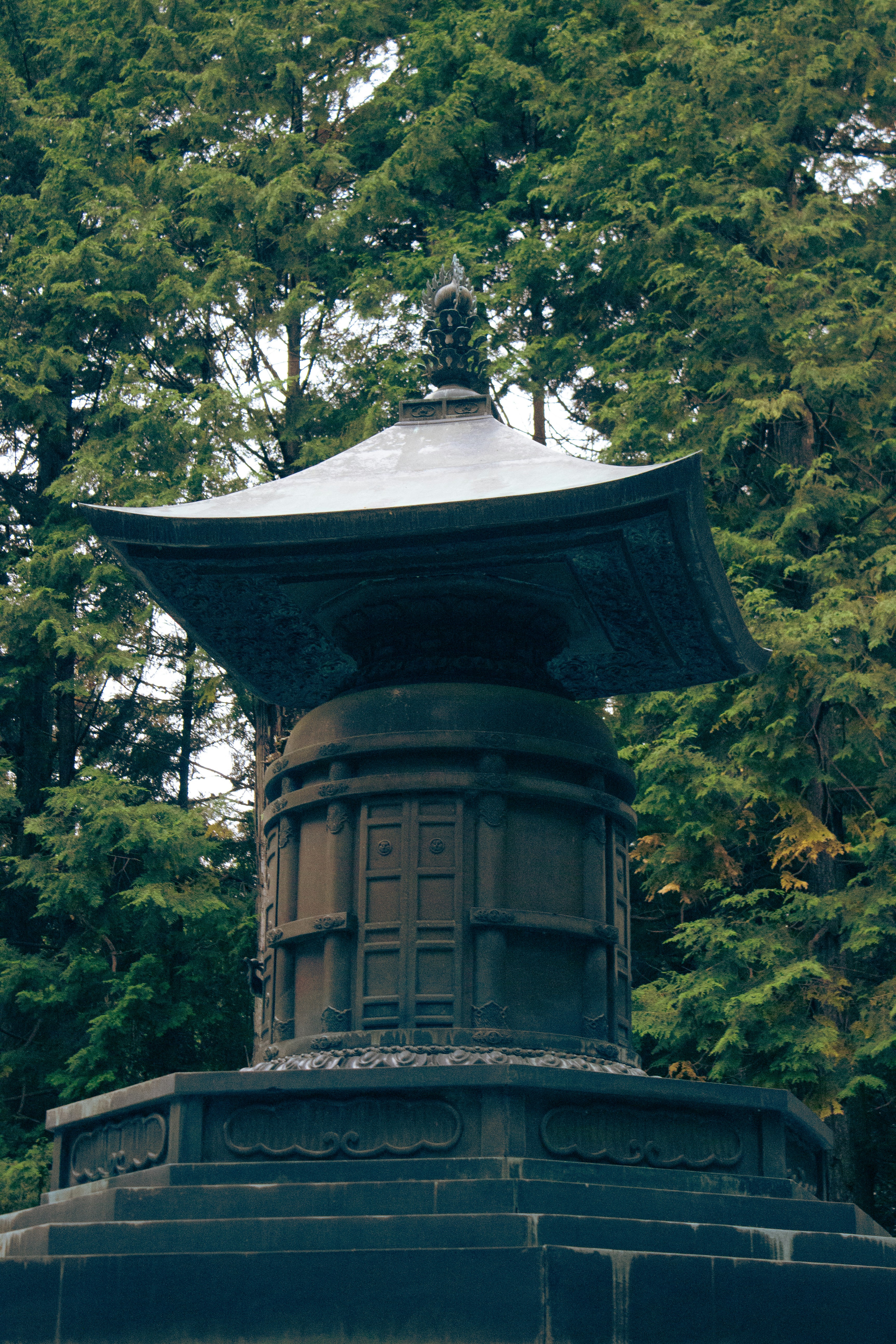 Stone pagoda in a lush green forest setting.