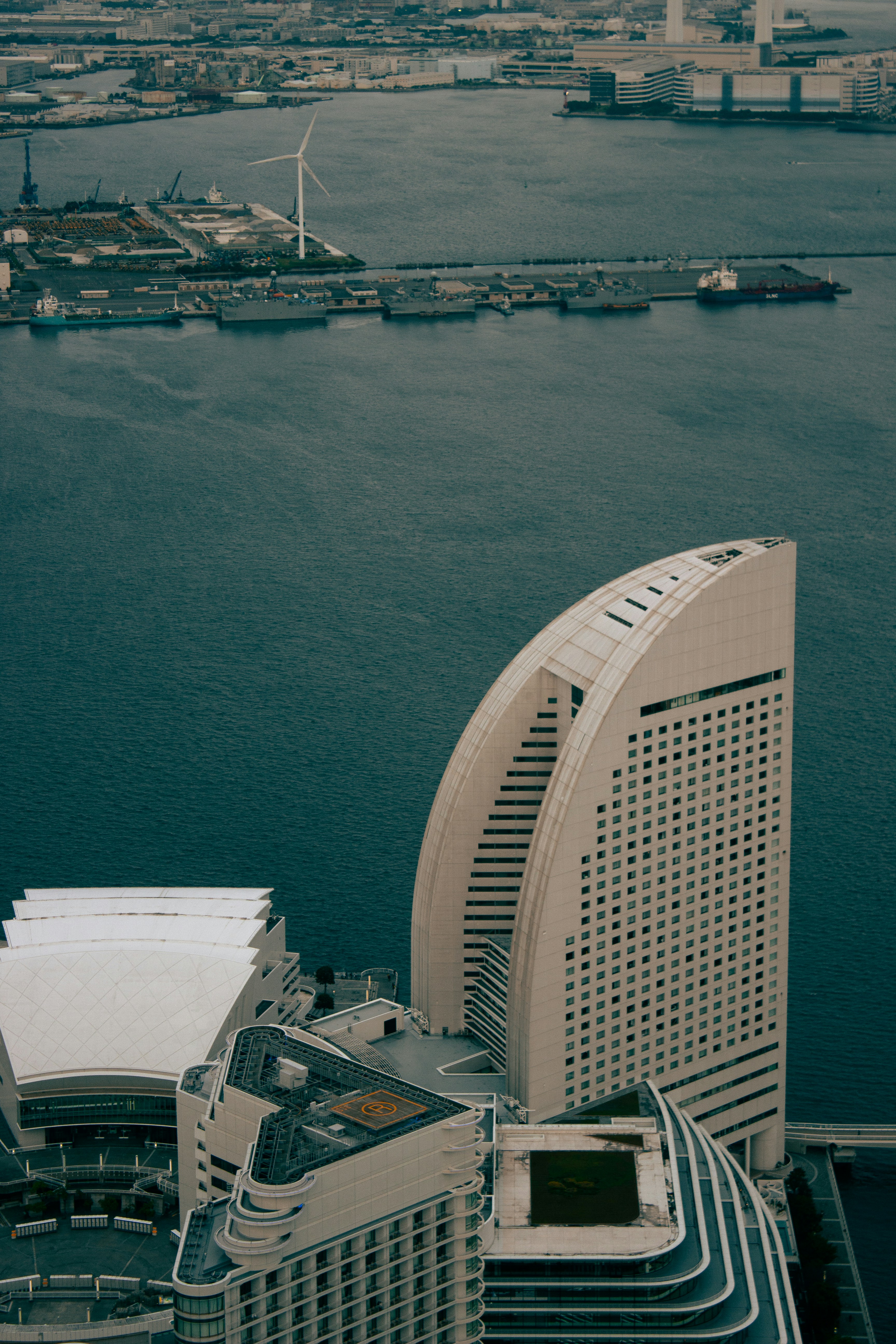 Moderne Wolkenkratzer überblicken einen geschäftigen Hafen mit Schiffen.