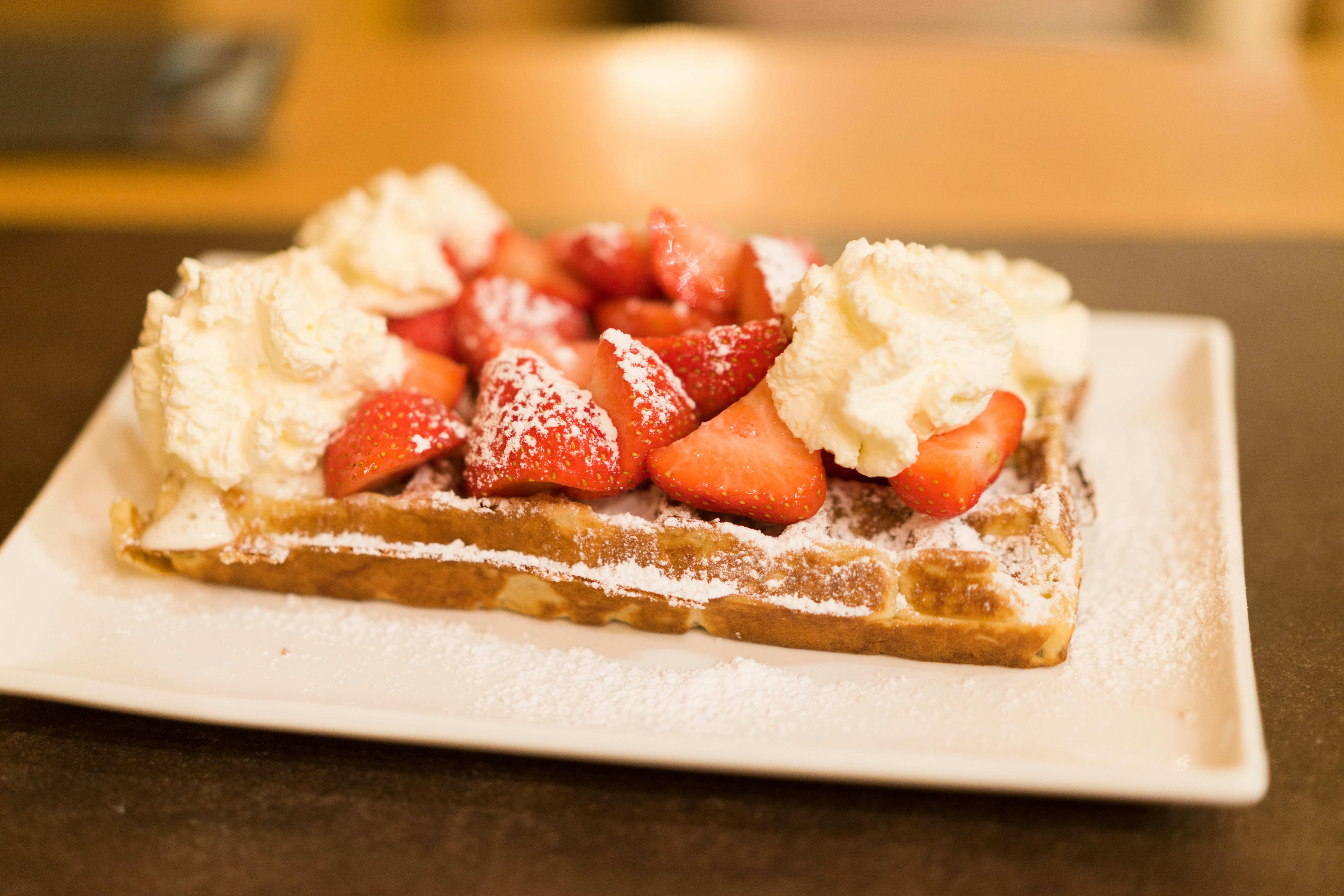 Waffle topped with strawberries and whipped cream