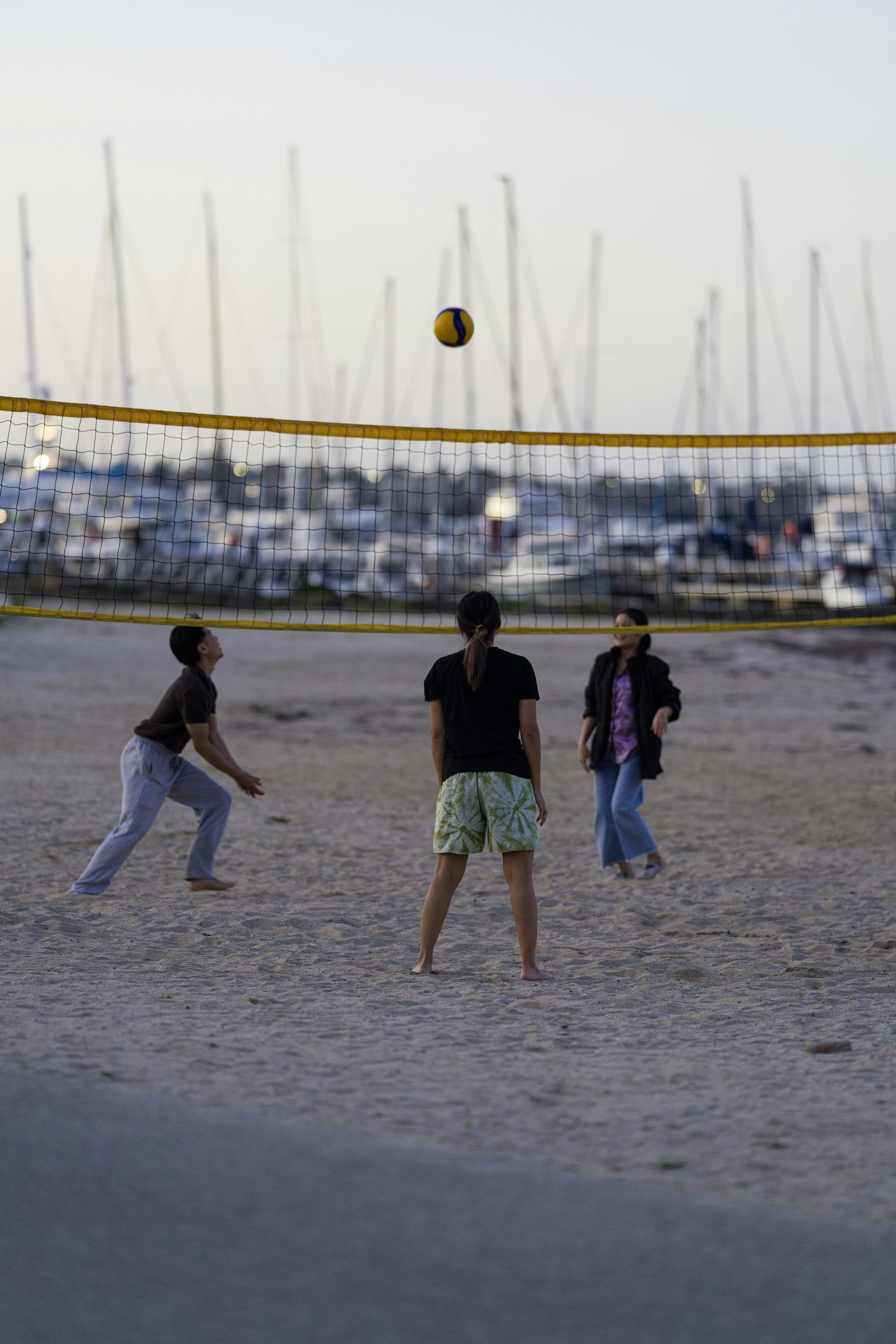 People playing volleyball on a sandy beach.