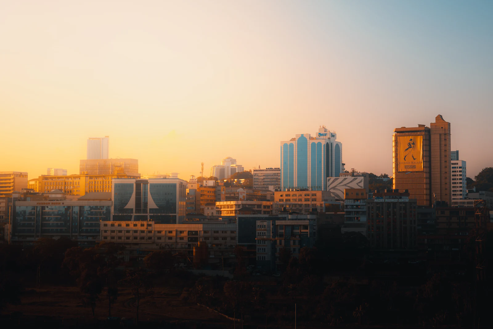 Kampala at sunset seen from Nsambya, office towers catching the last light.