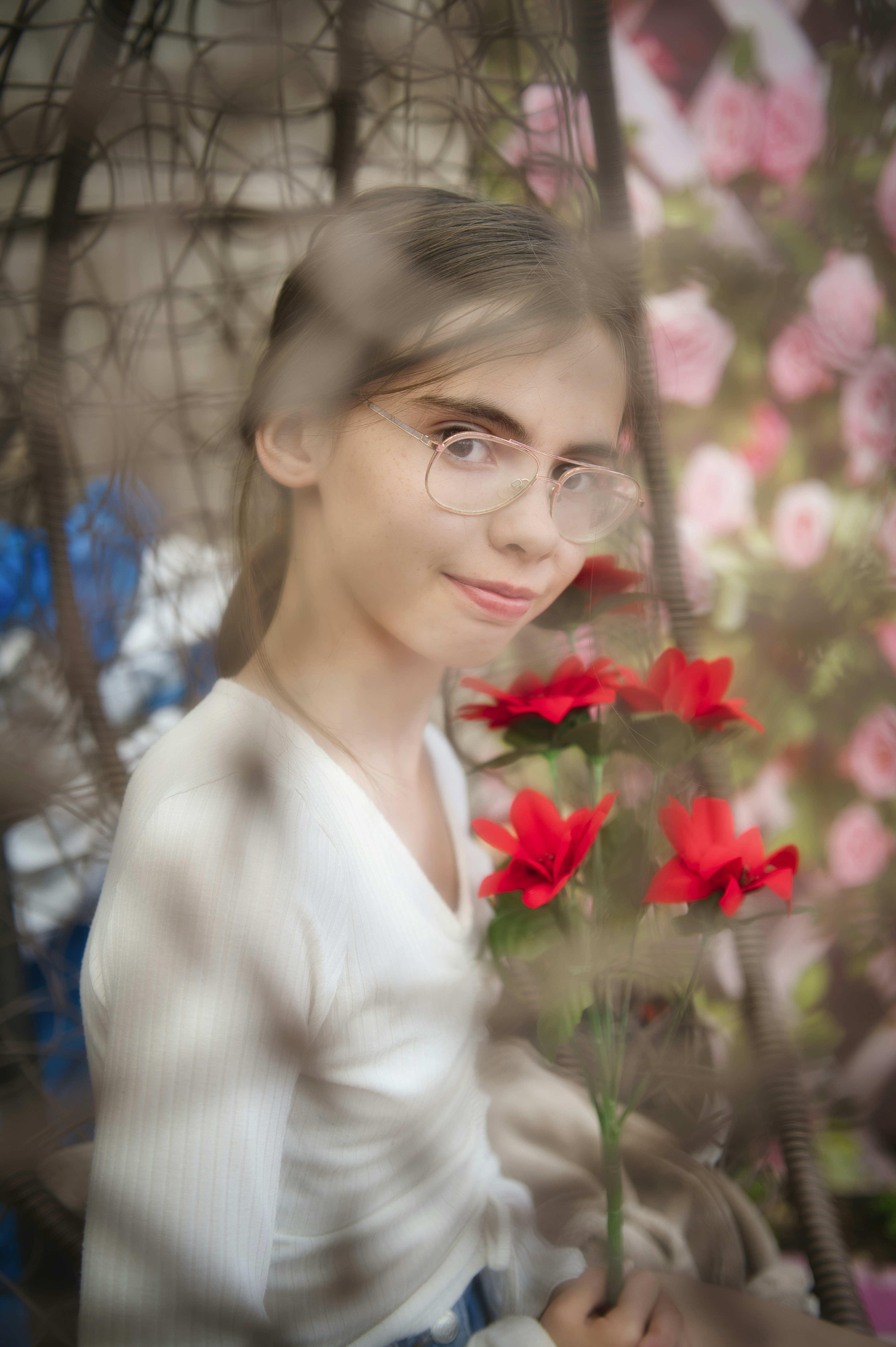 Young girl with glasses holding red flowers