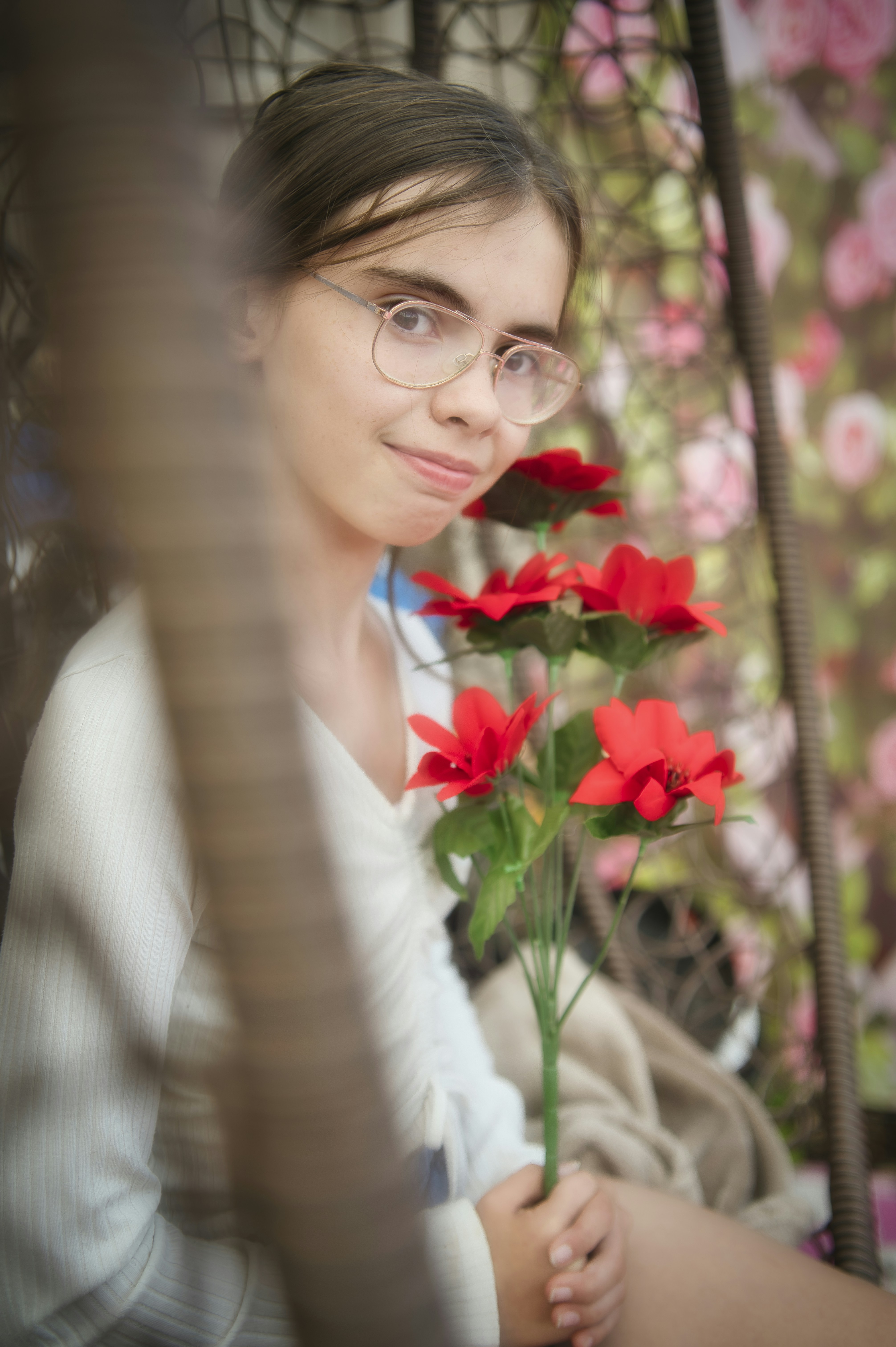 Young girl with glasses holding red flowers