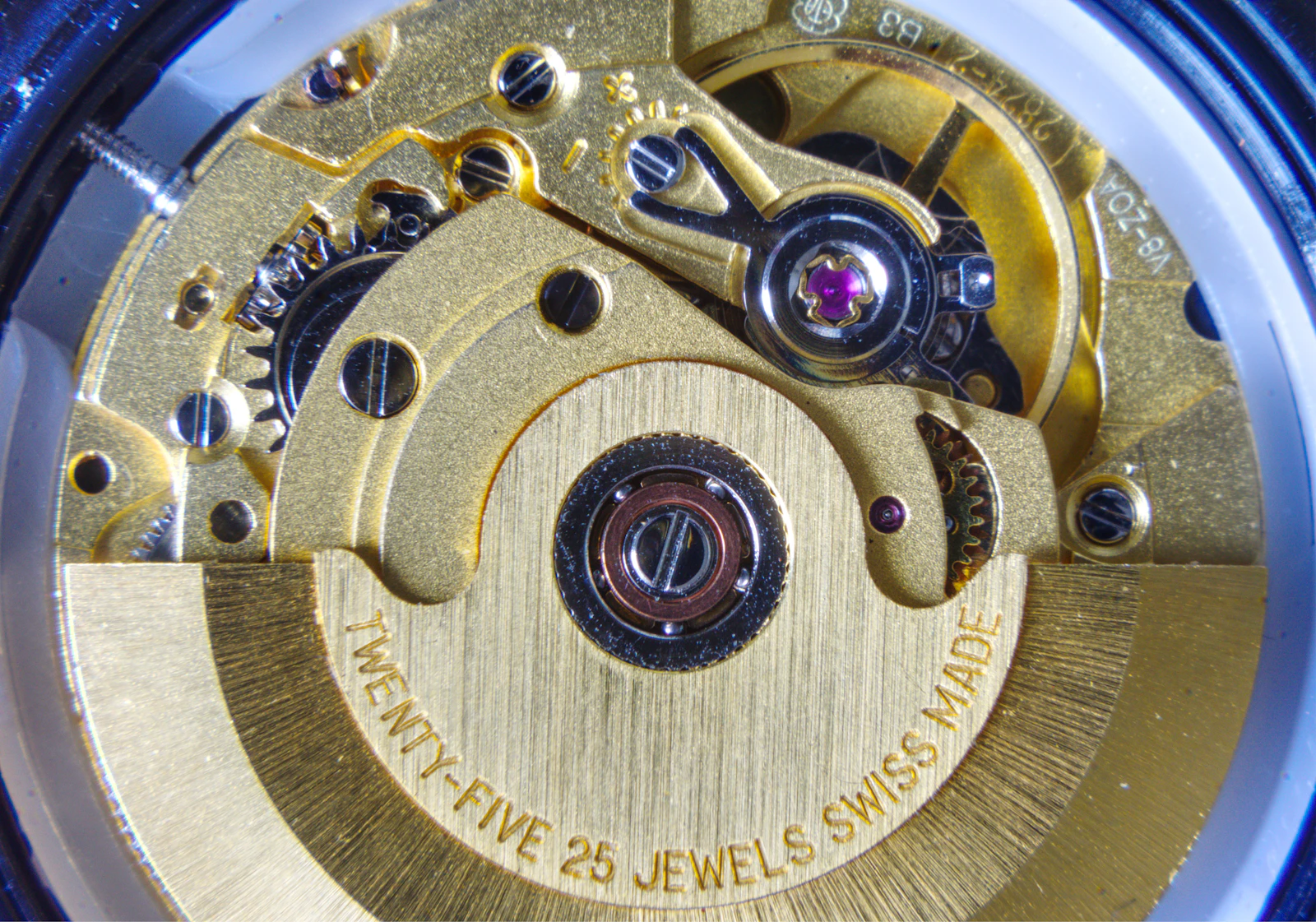 Macro view of a mechanical watch movement — gears, jewels and blued screws