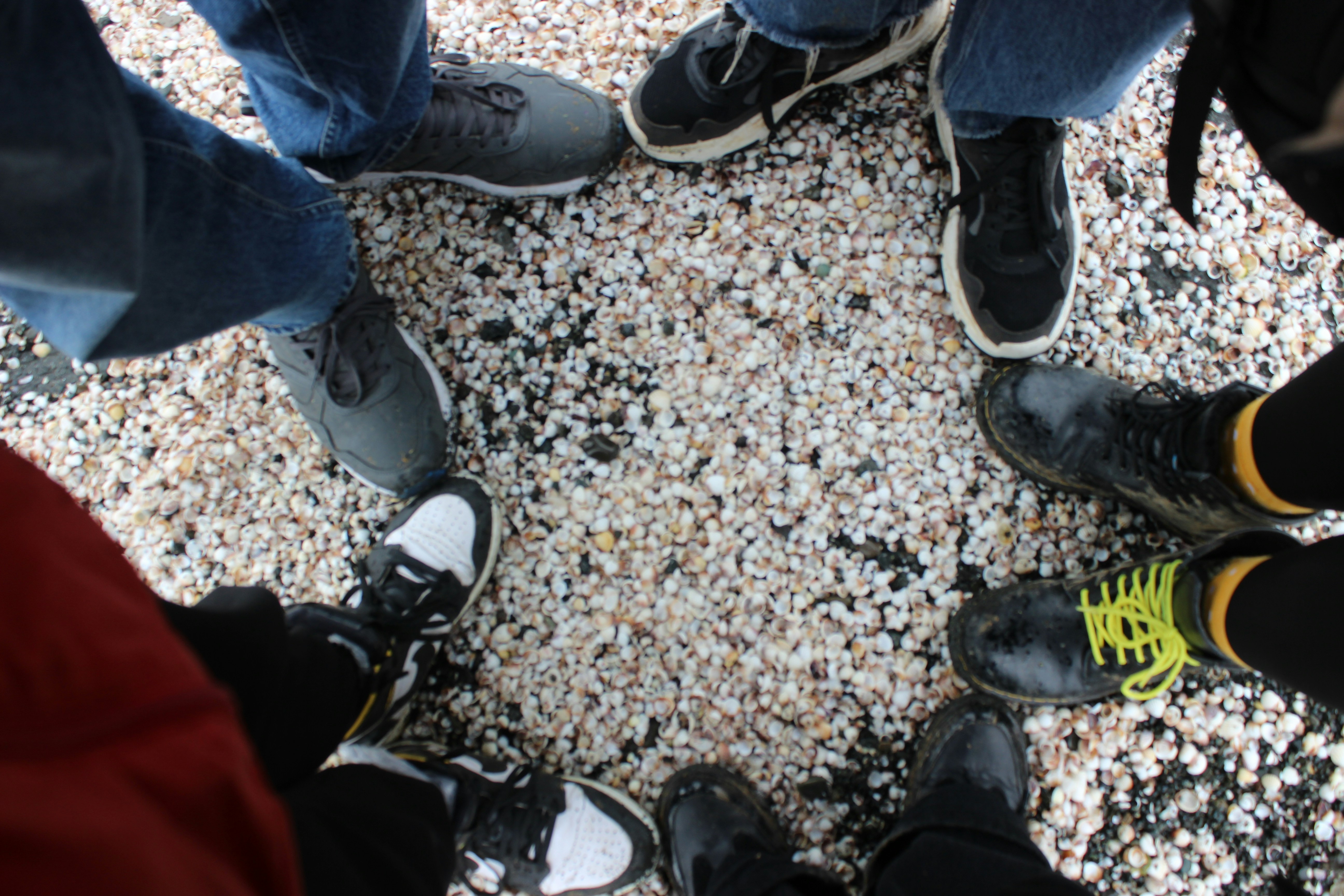 People standing in a circle on gravel