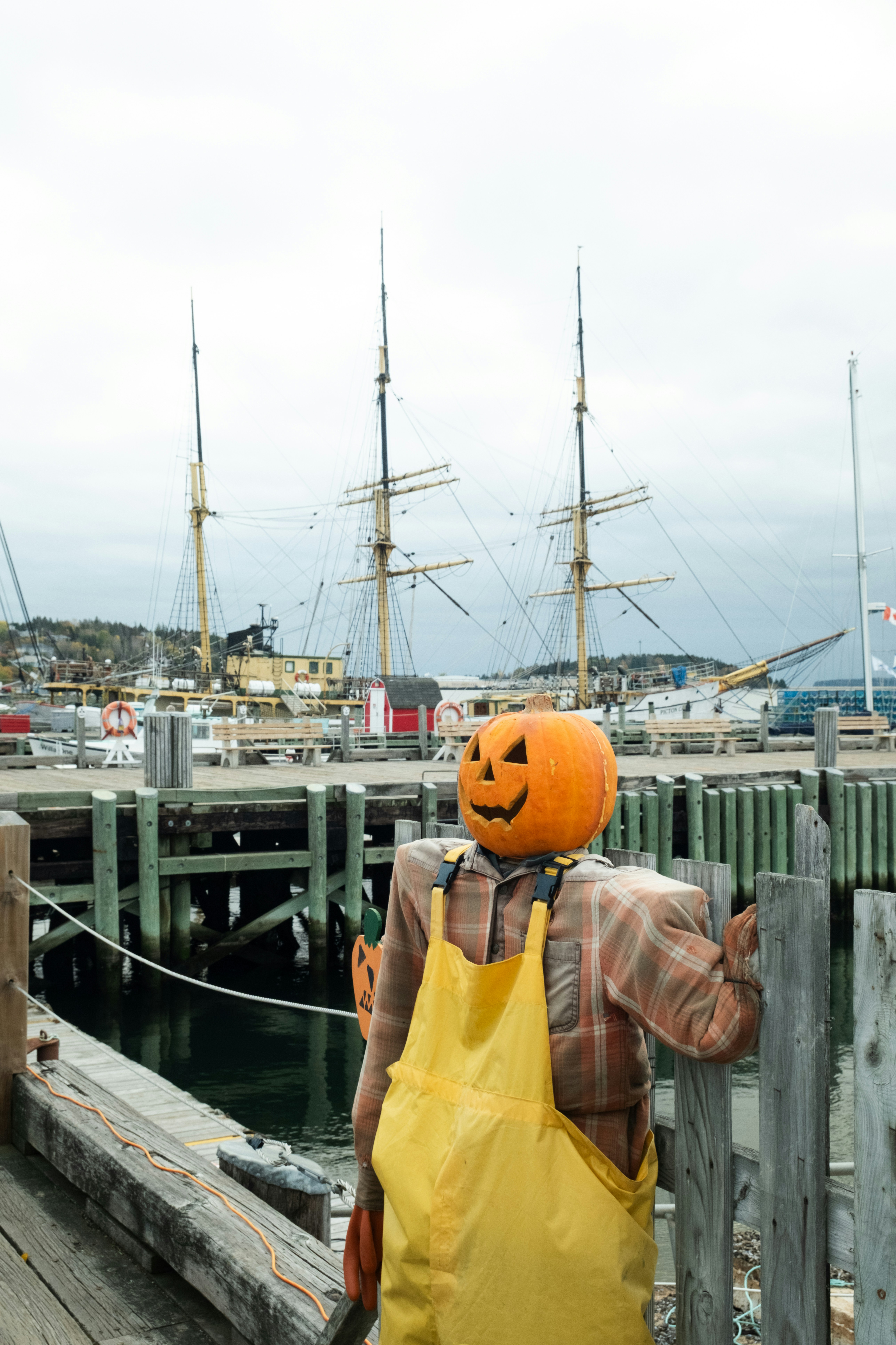 Scarecrow with pumpkin head on a dock