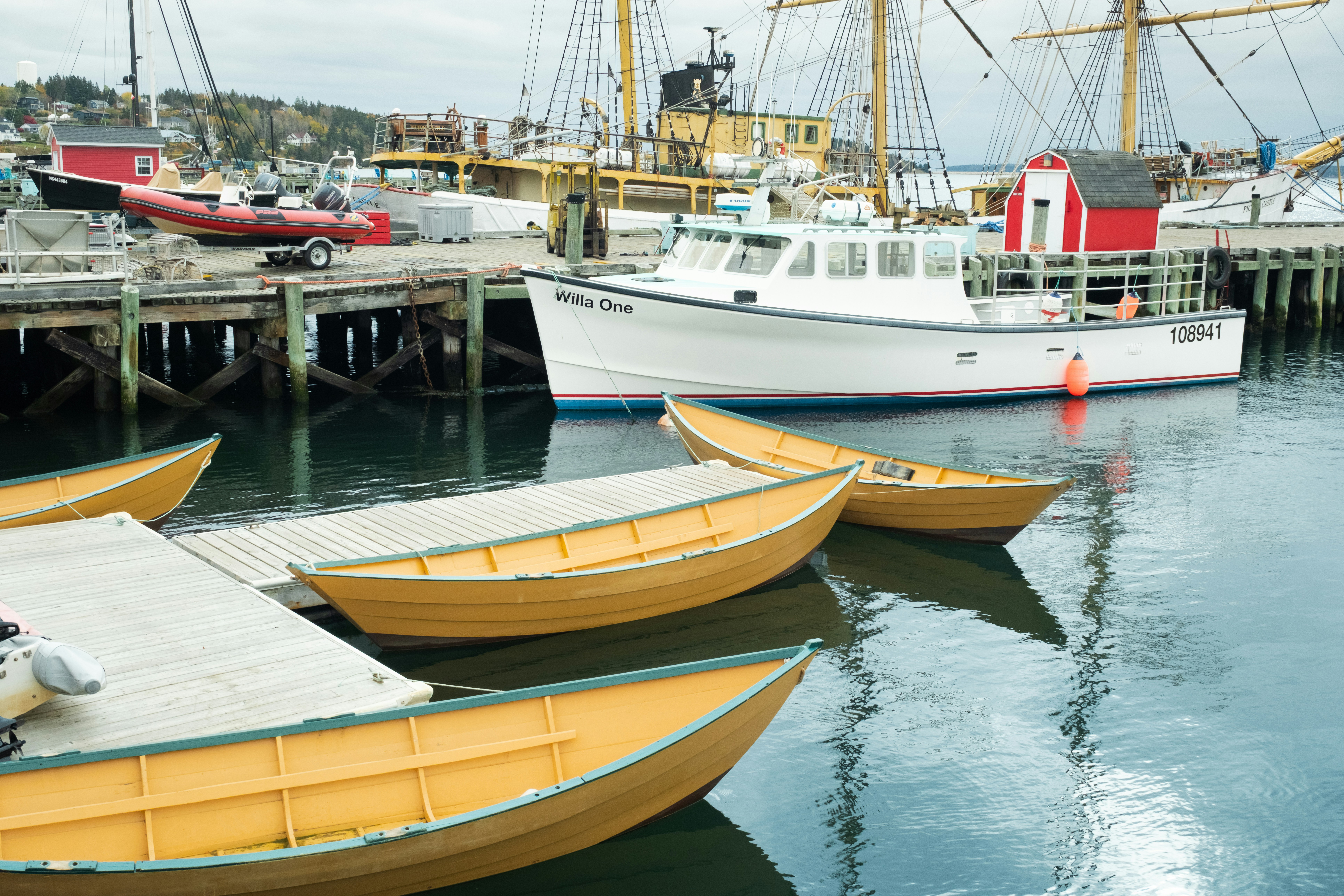 Yellow boats docked at a harbor with a large ship.