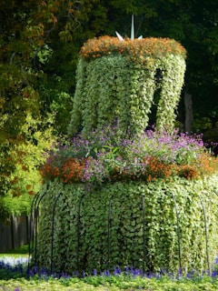 A topiary sculpture adorned with colorful flowers in a garden