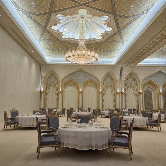 Elegant ballroom with round tables and ornate ceiling