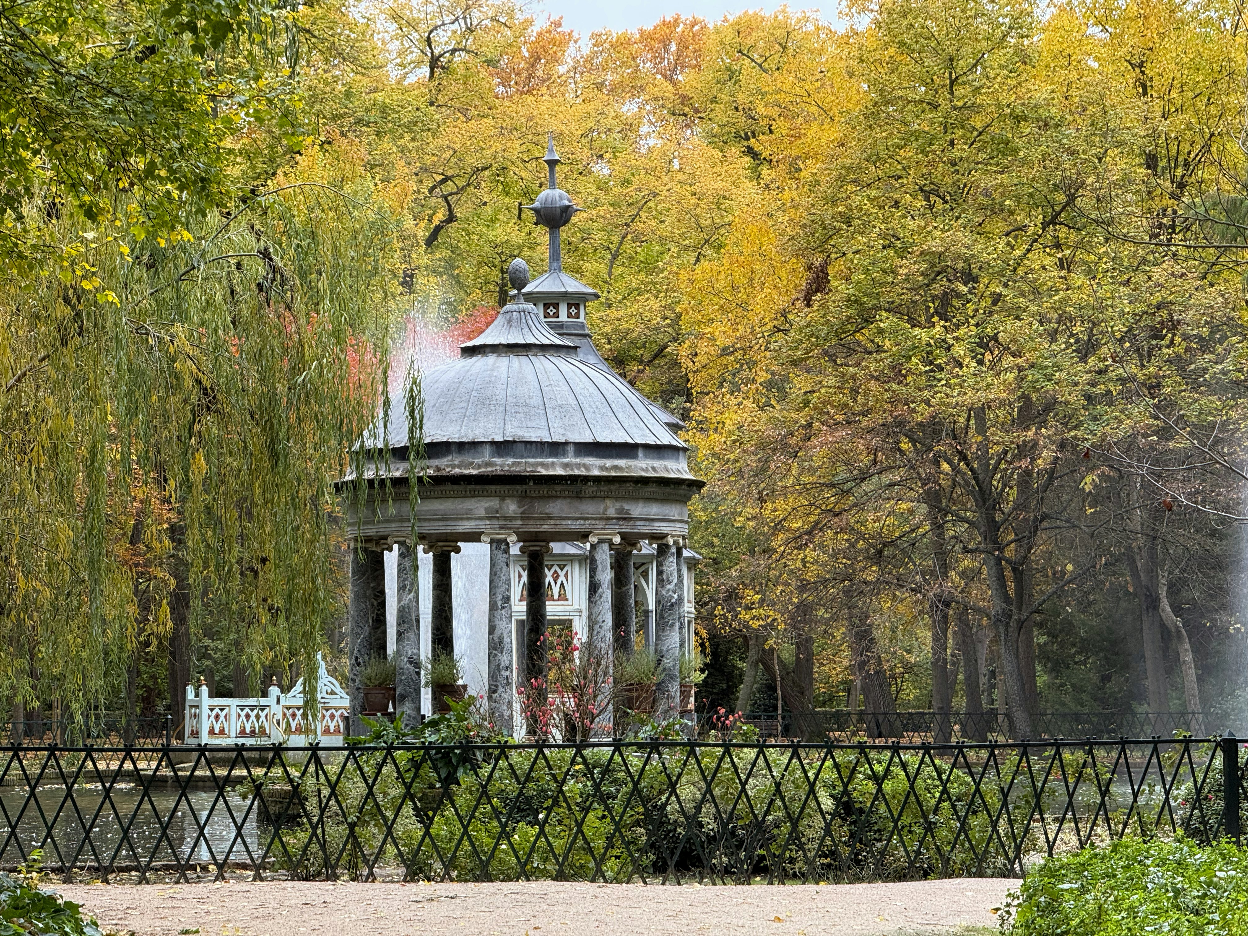 Ornate gazebo in a park with autumn trees