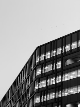 Modern office building with lit windows against sky