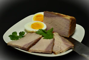 Sliced smoked meat with hard-boiled eggs and parsley