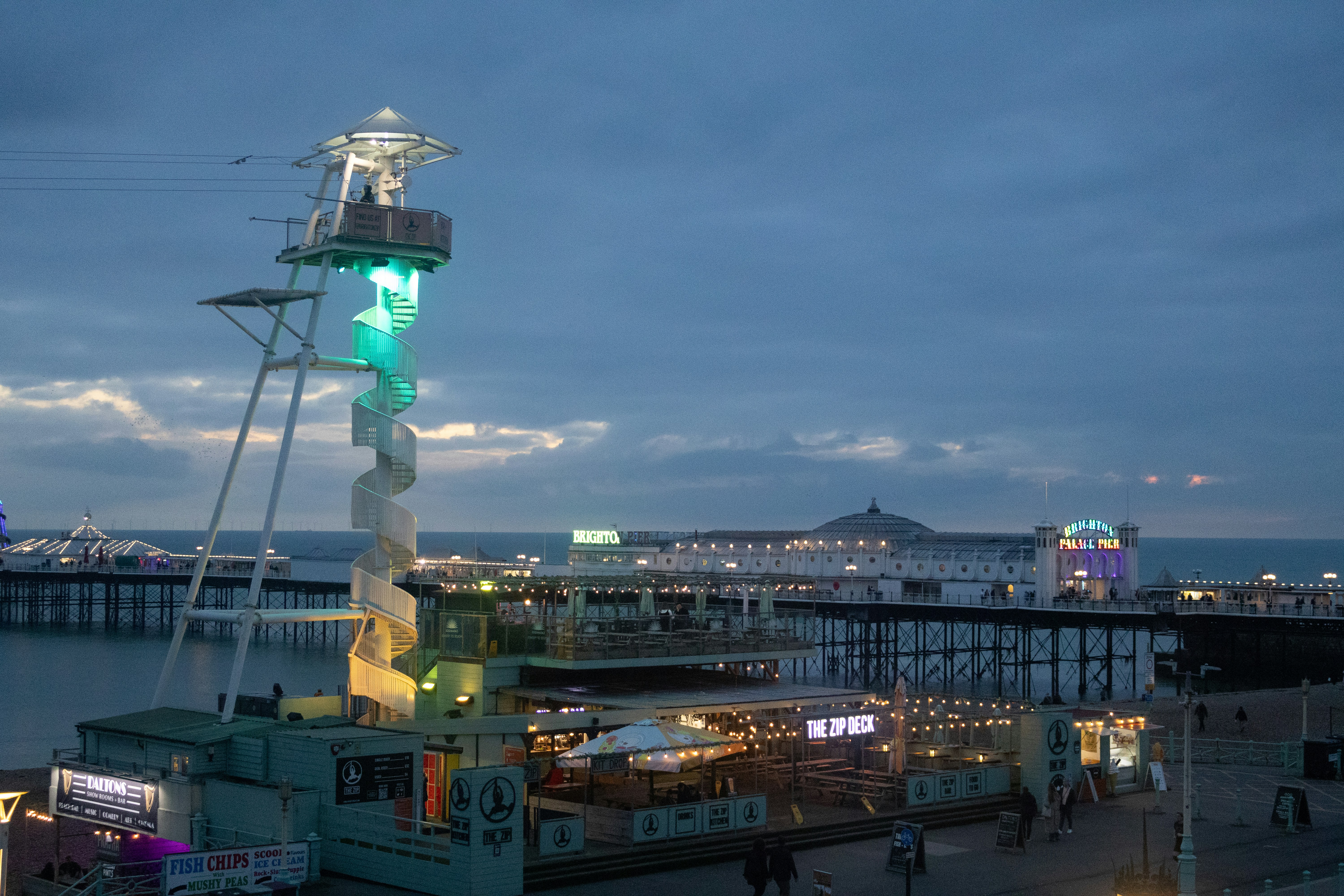Lighthouse structure with pier and ocean at dusk