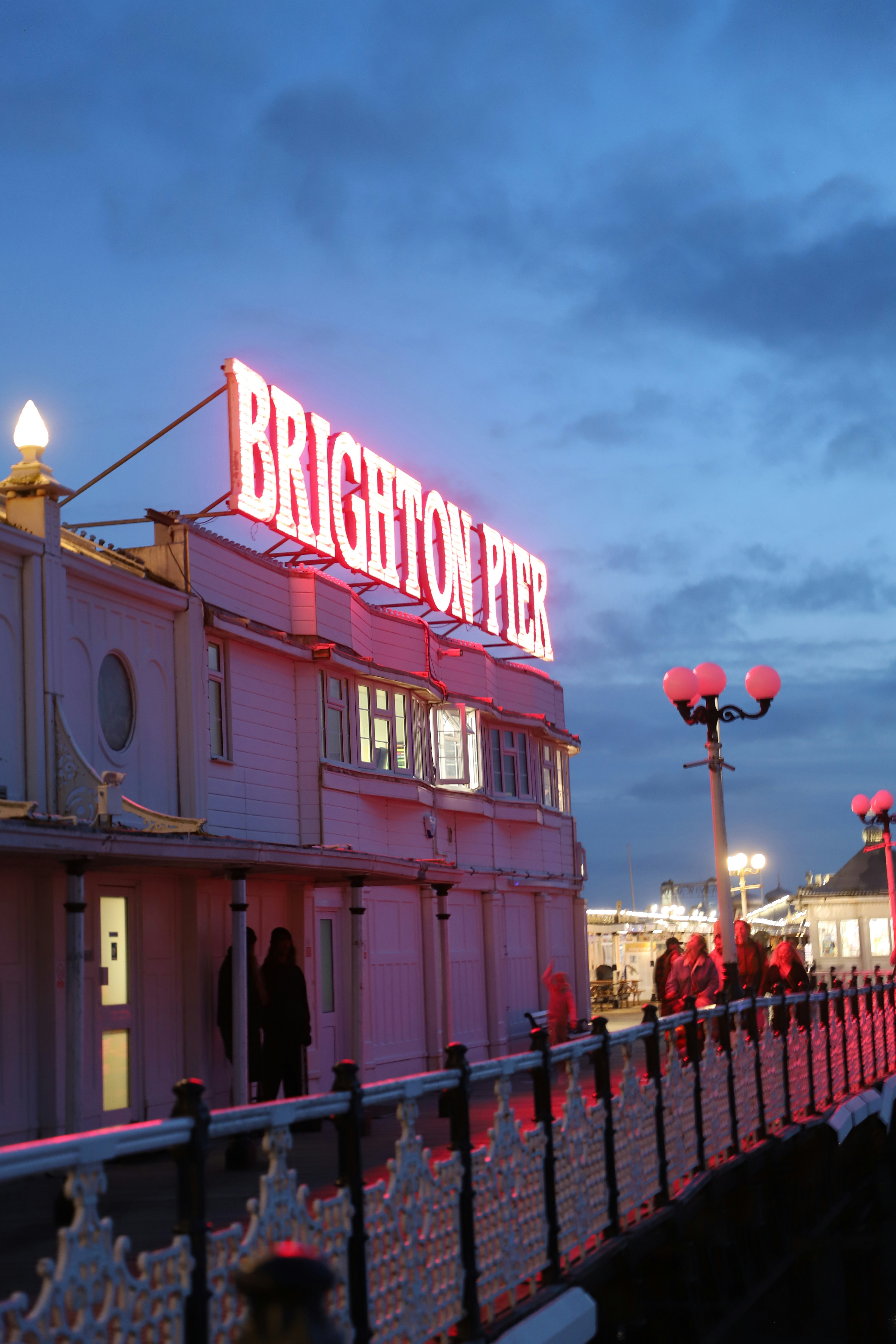 Brighton pier illuminated at dusk with neon lights