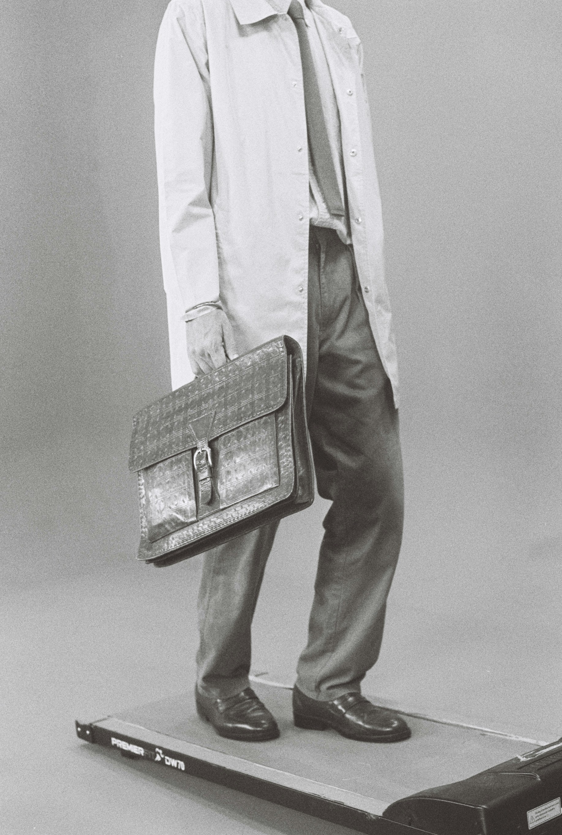 Man in suit carrying briefcase on treadmill