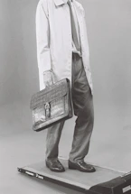 Man in suit carrying briefcase on treadmill
