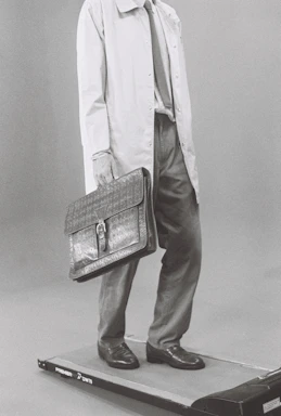Man in suit carrying briefcase on treadmill