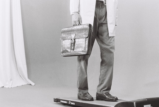 Man in lab coat holding briefcase on scale