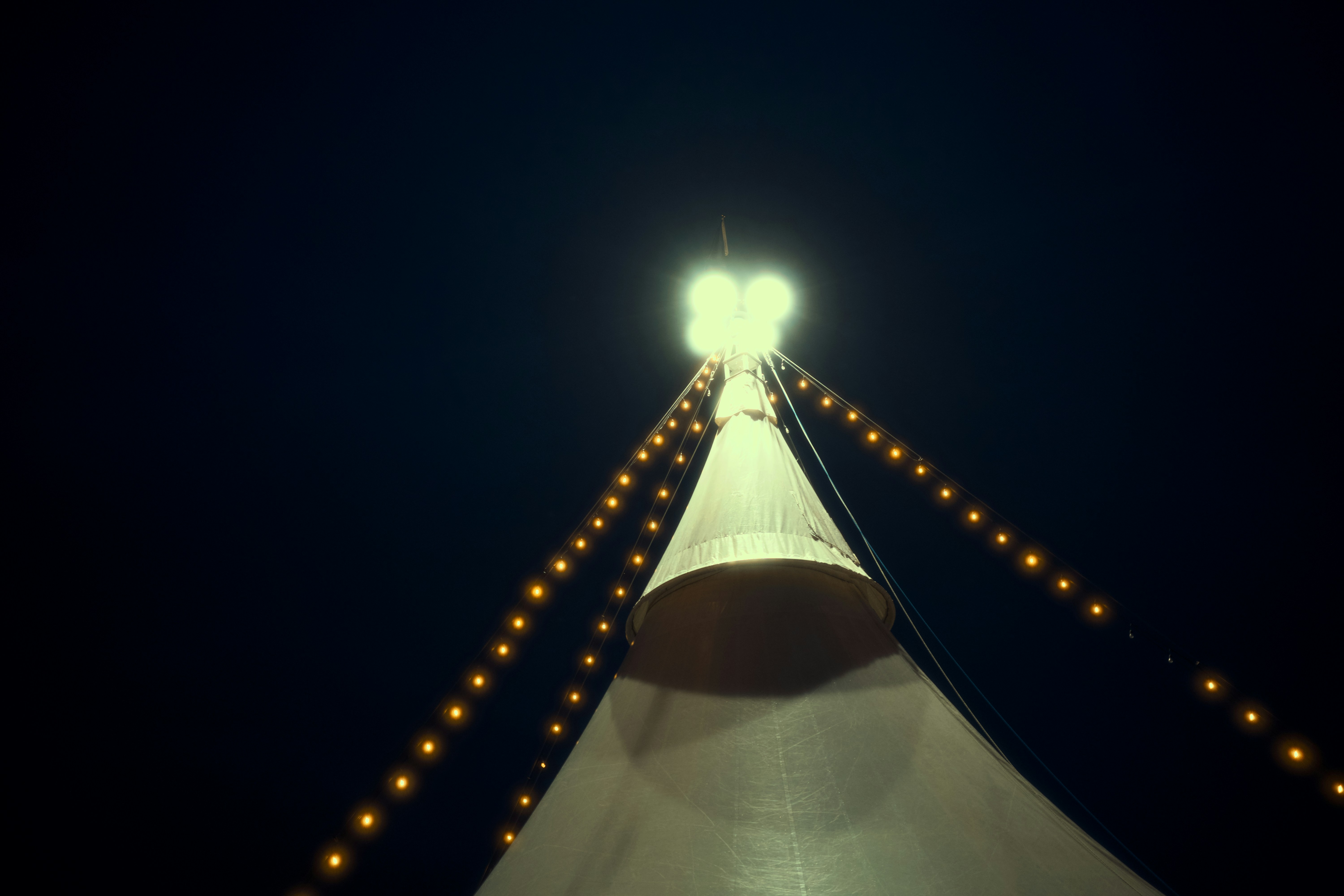 Bright lights illuminate a tent at night.