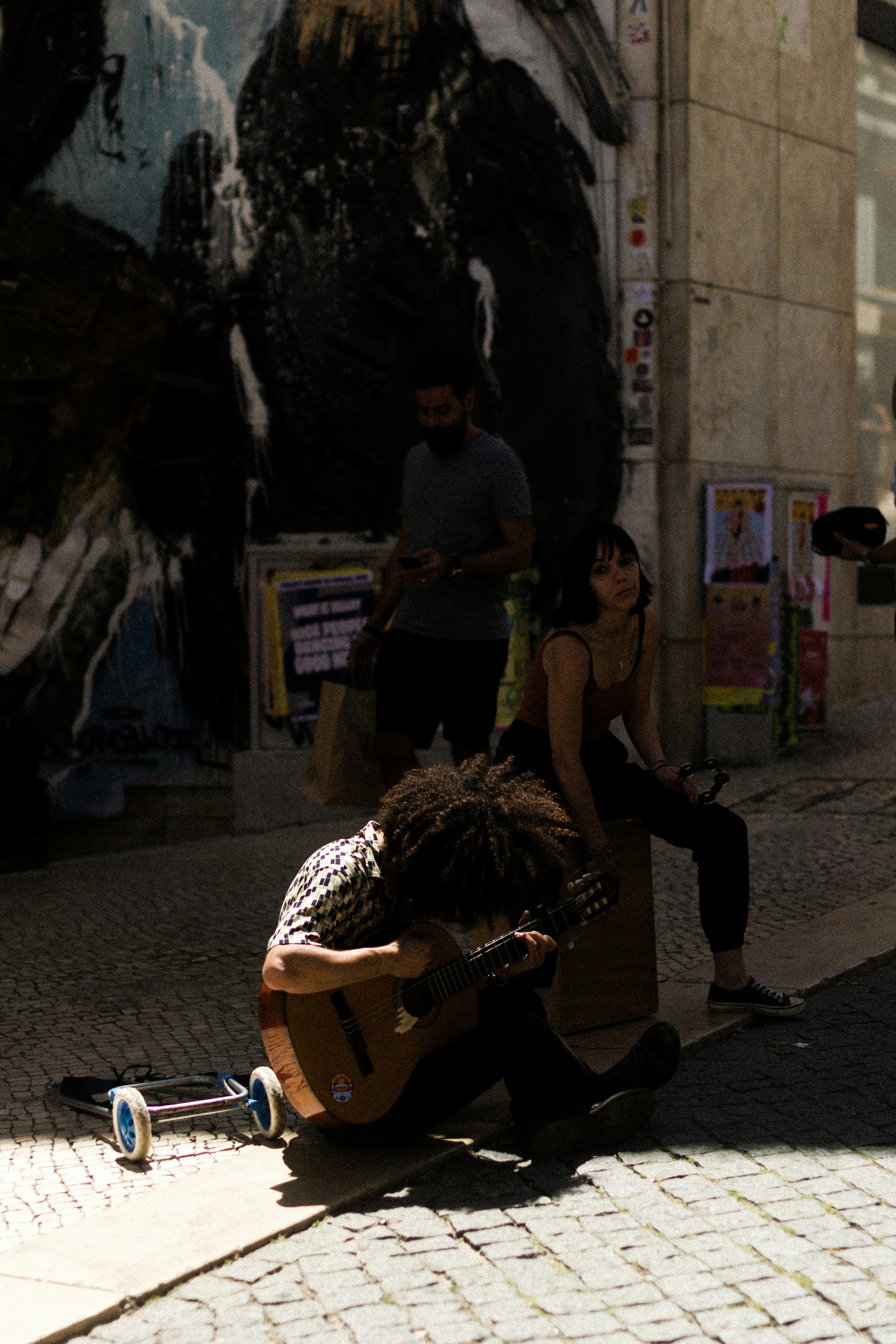 Musicista suona la chitarra su strada di ciottoli