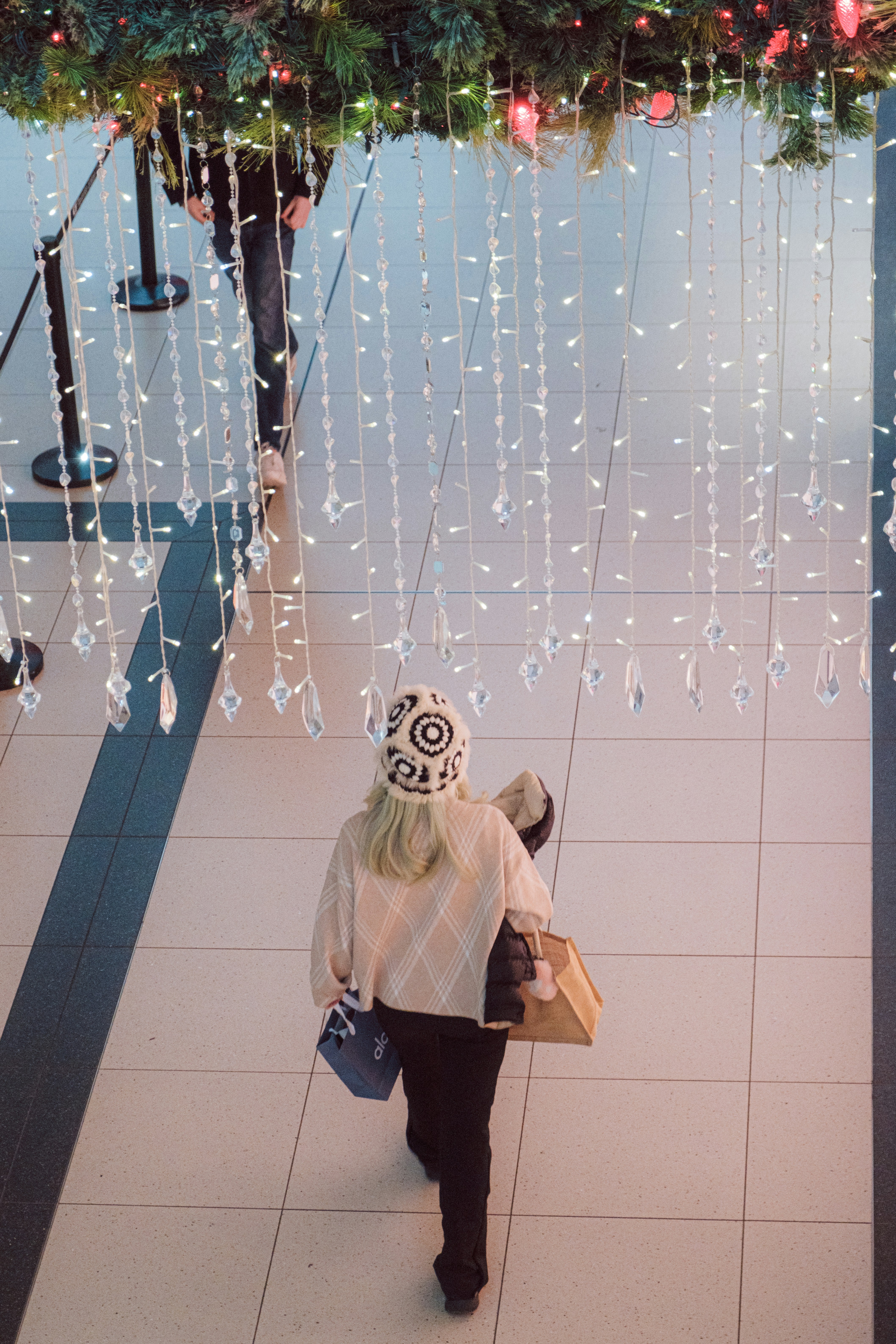 Woman walks under festive holiday lights