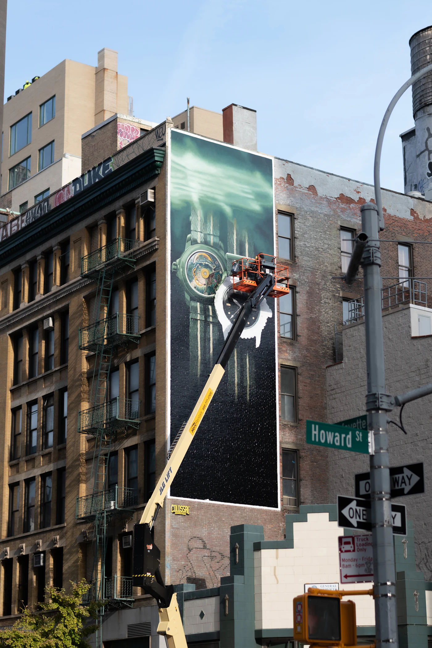 Crew installing a large printed mural on a building facade