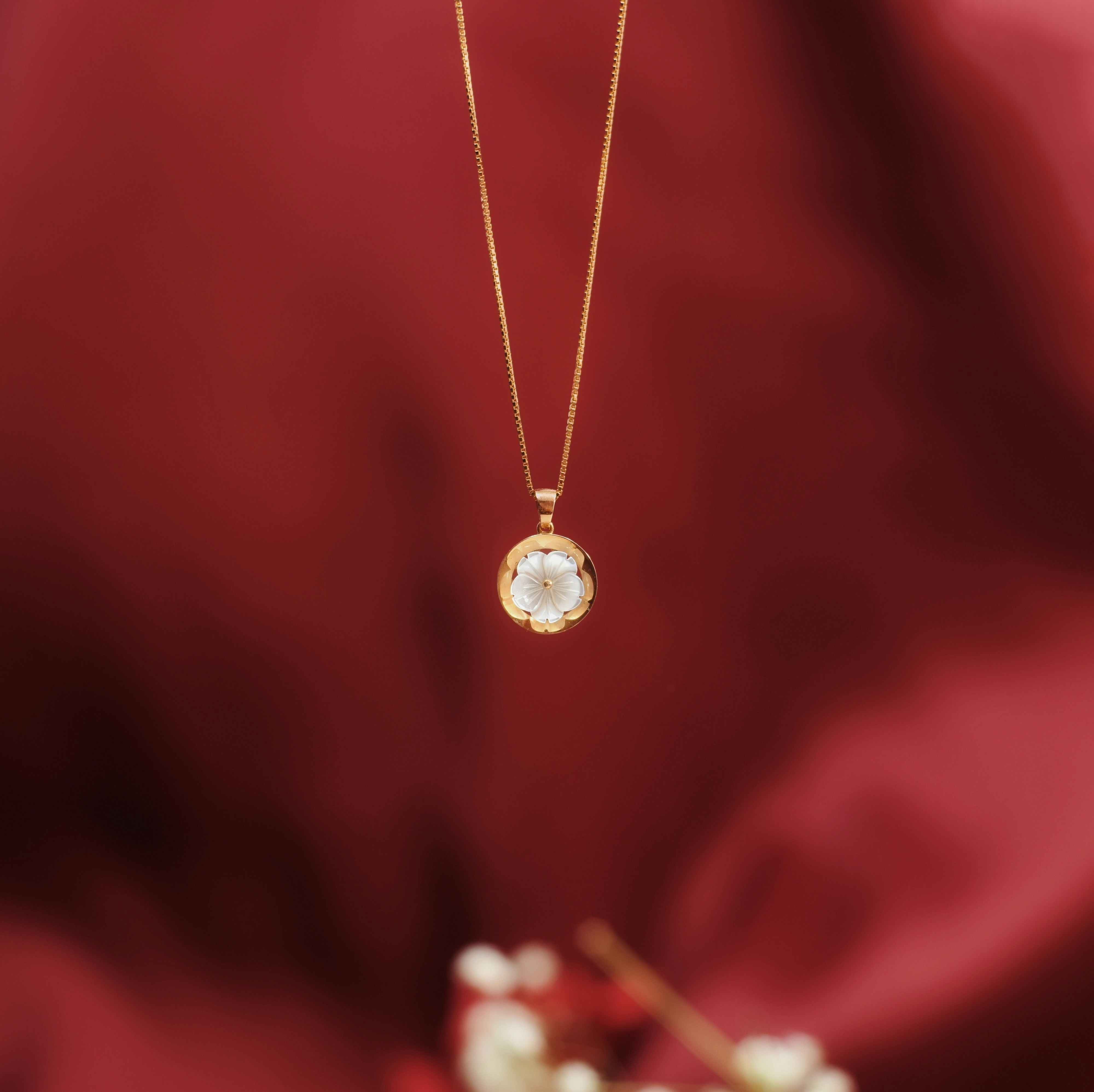 Rose gold necklace with a clear gemstone pendant.