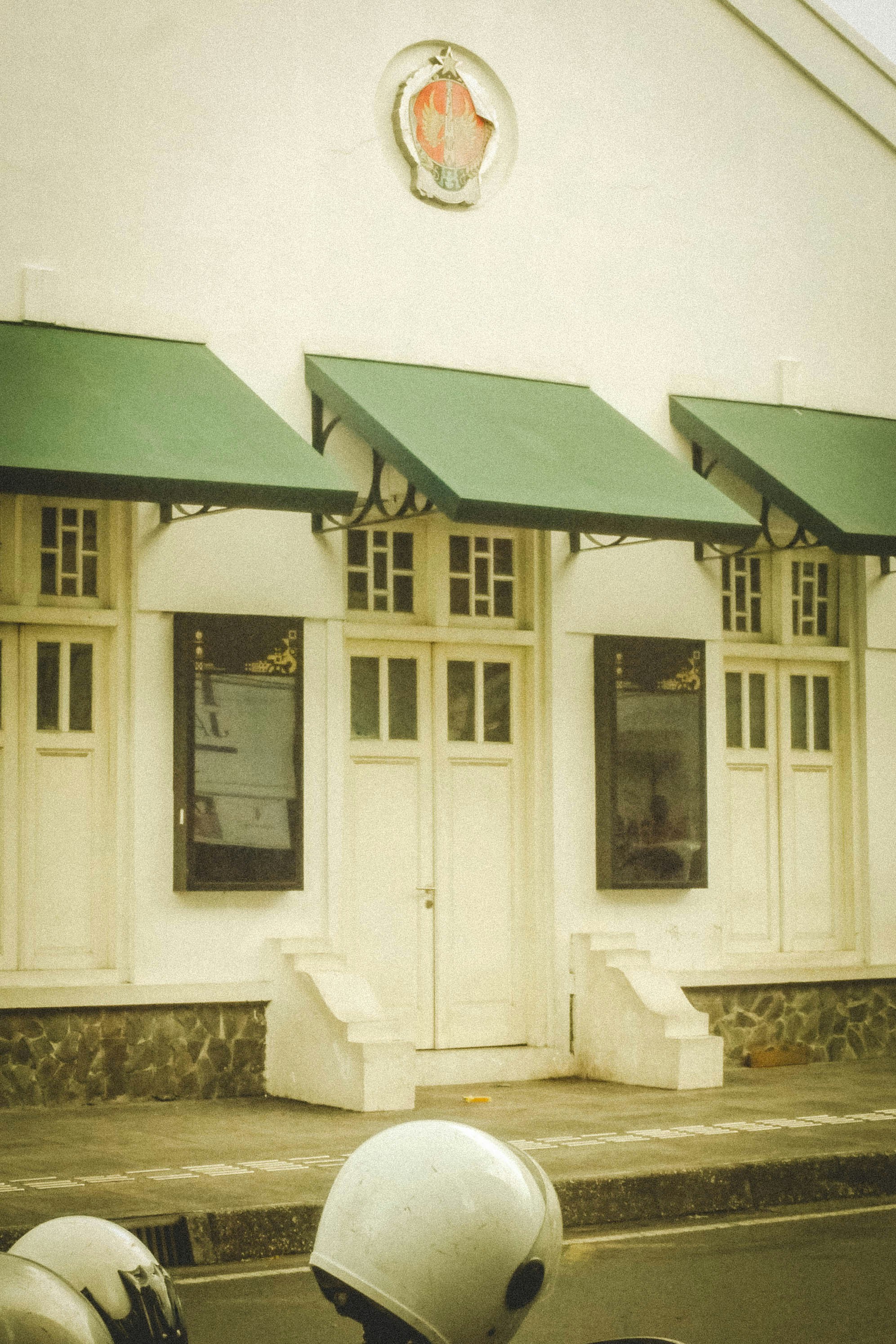 White building with green awnings and windows
