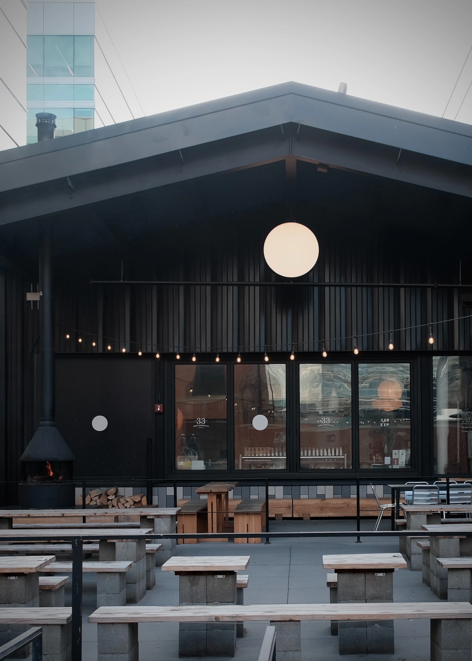 Outdoor patio seating with string lights and a built-in fireplace