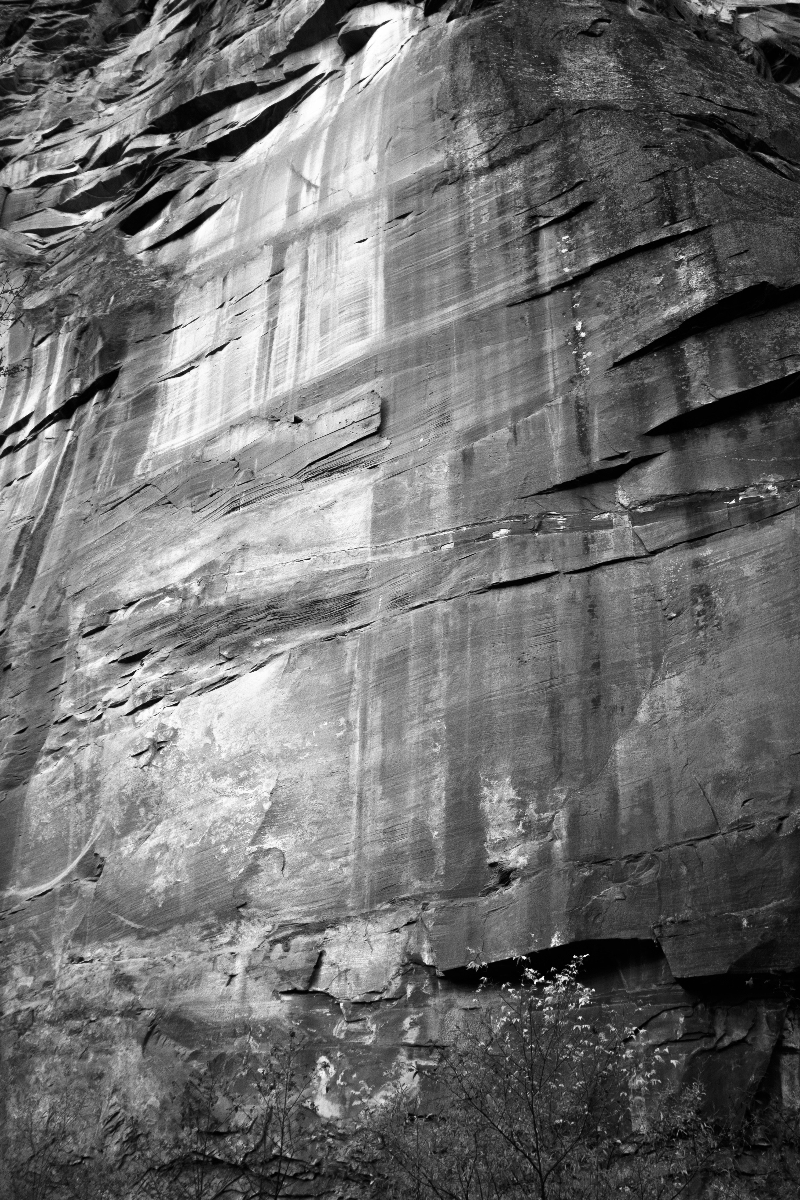 Textured rock face with vertical water streaks