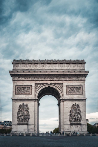 The arc de triomphe in paris under a cloudy sky