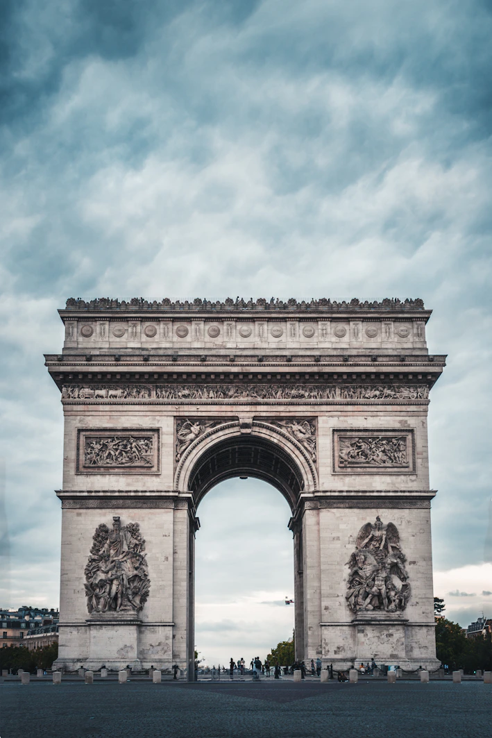 The arc de triomphe in paris under a cloudy sky