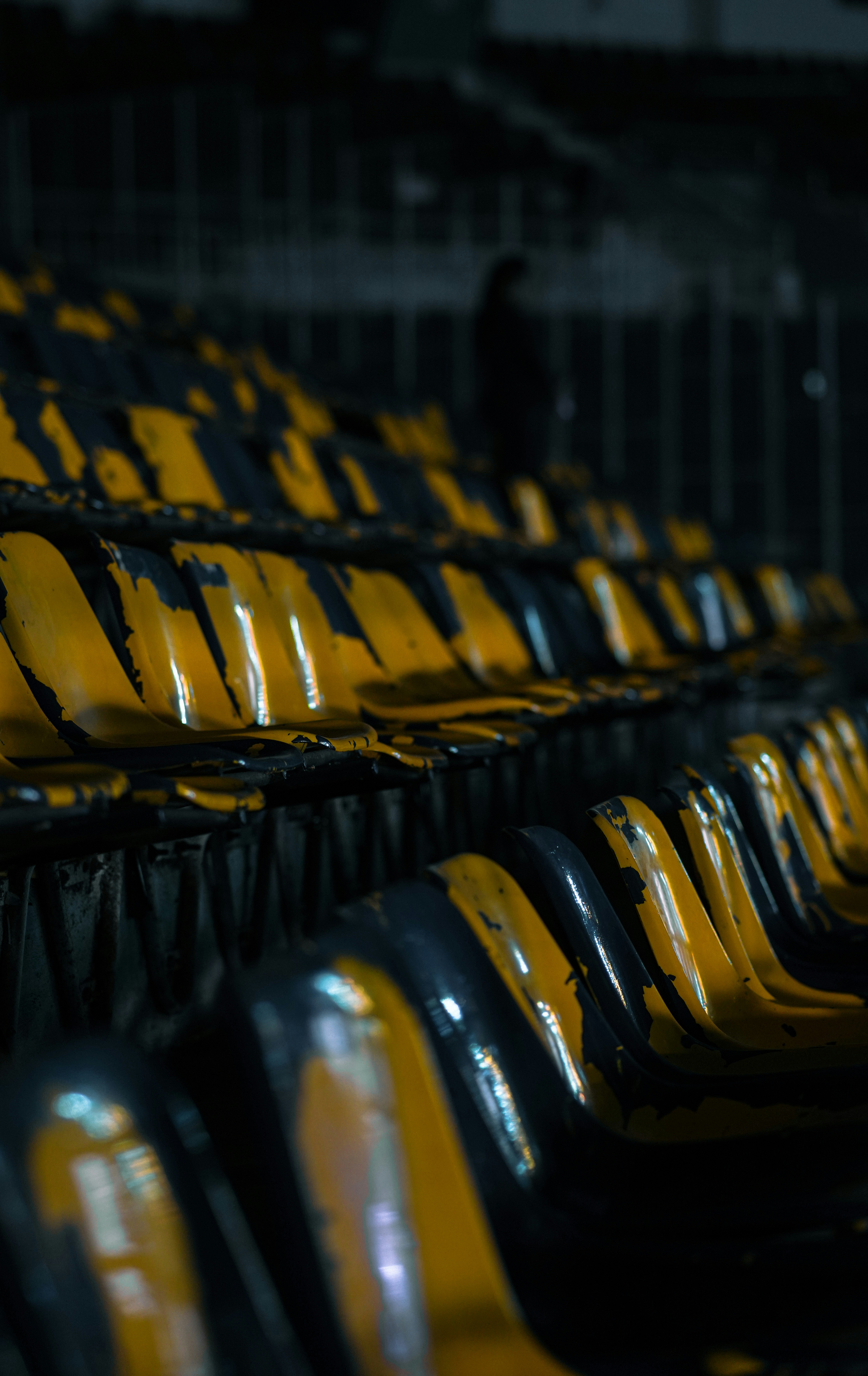Filas de asientos vacíos en el estadio con rayas amarillas y negras.