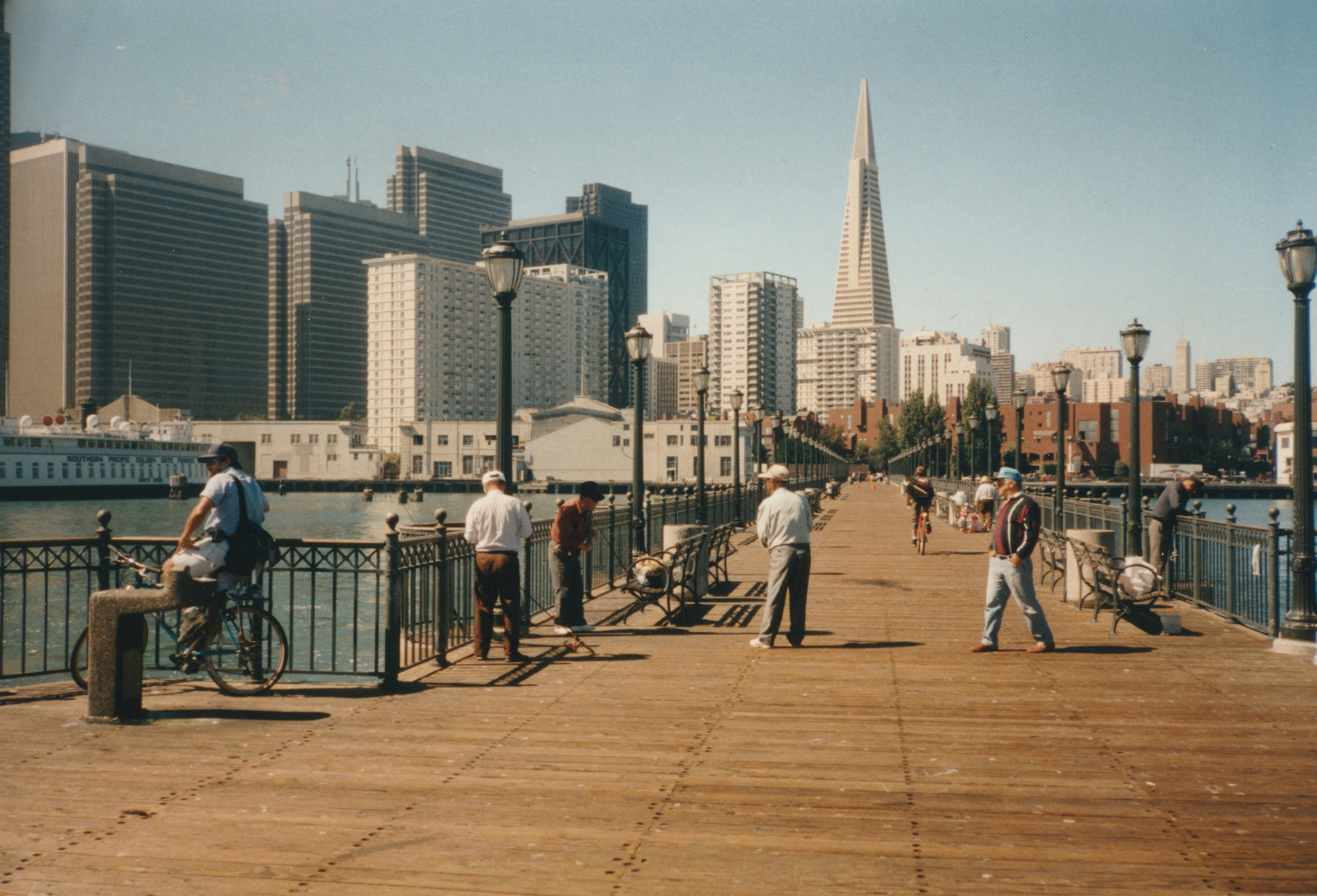 People fishing on a pier with city skyline background