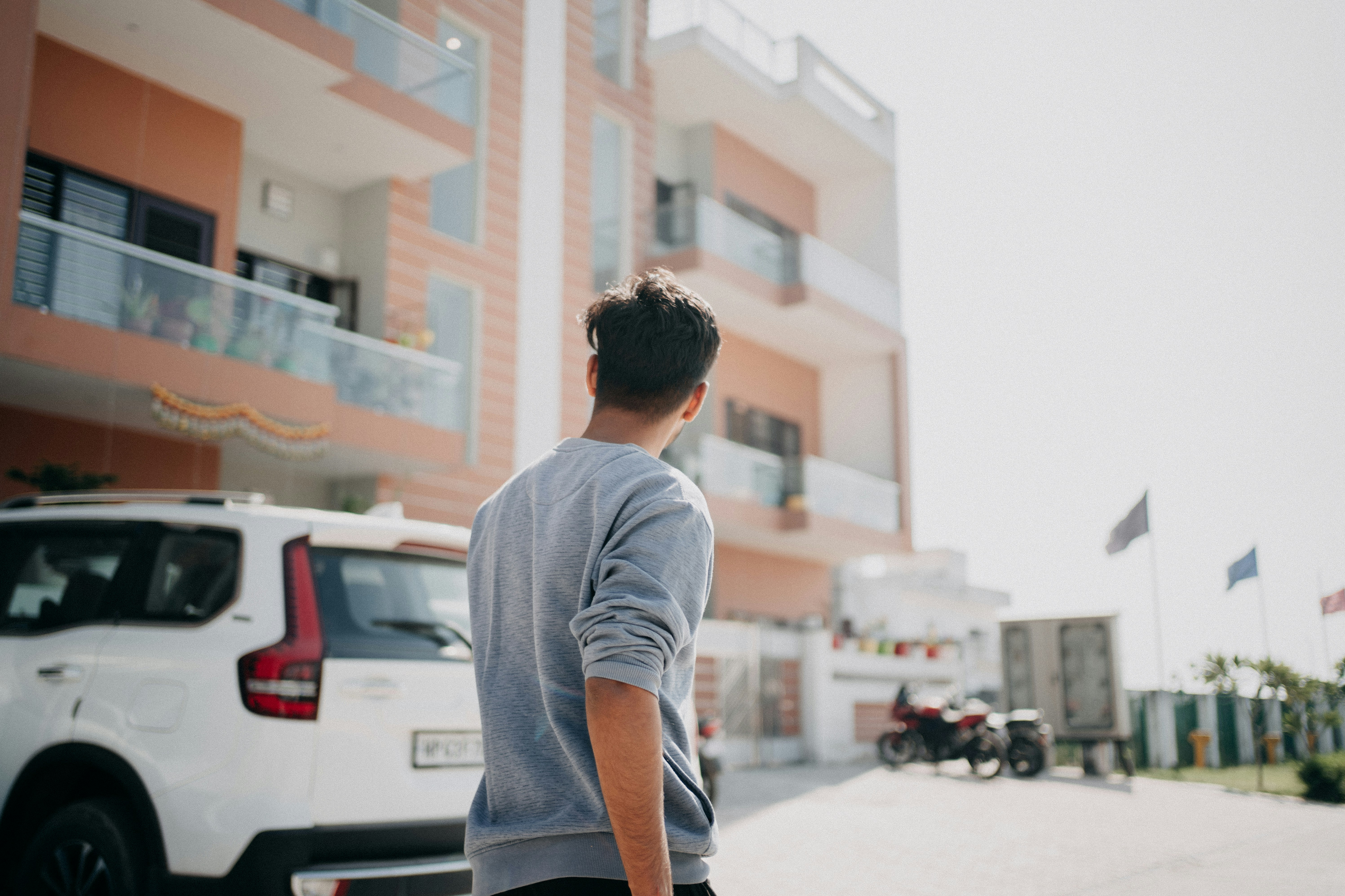 Young man looks away from camera near building.