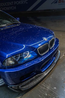 Blue BMW car with water droplets during wash