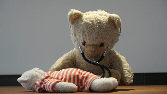 Teddy bear with stethoscope checks another bear