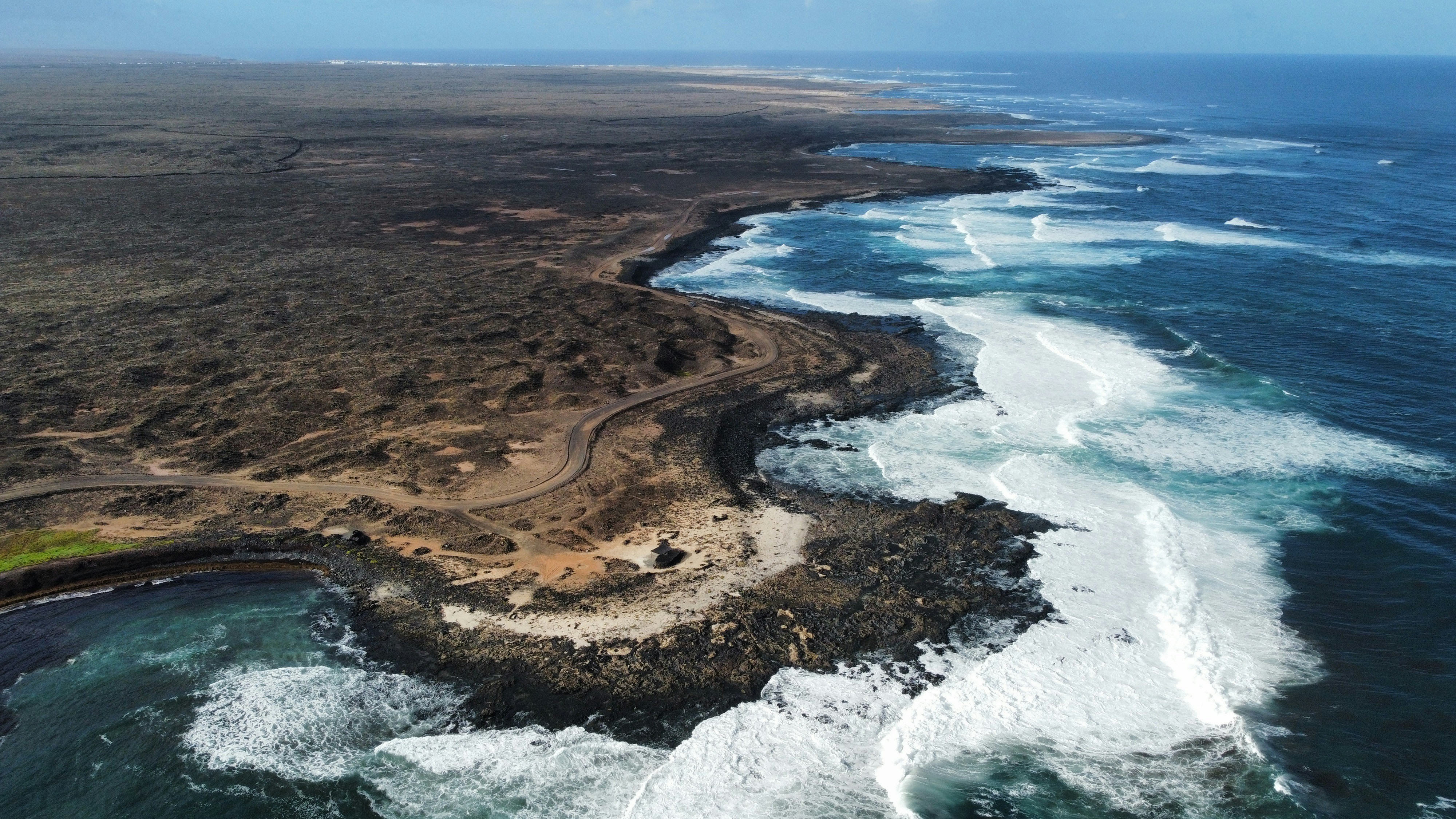 Rocky coastline with crashing waves and dark land