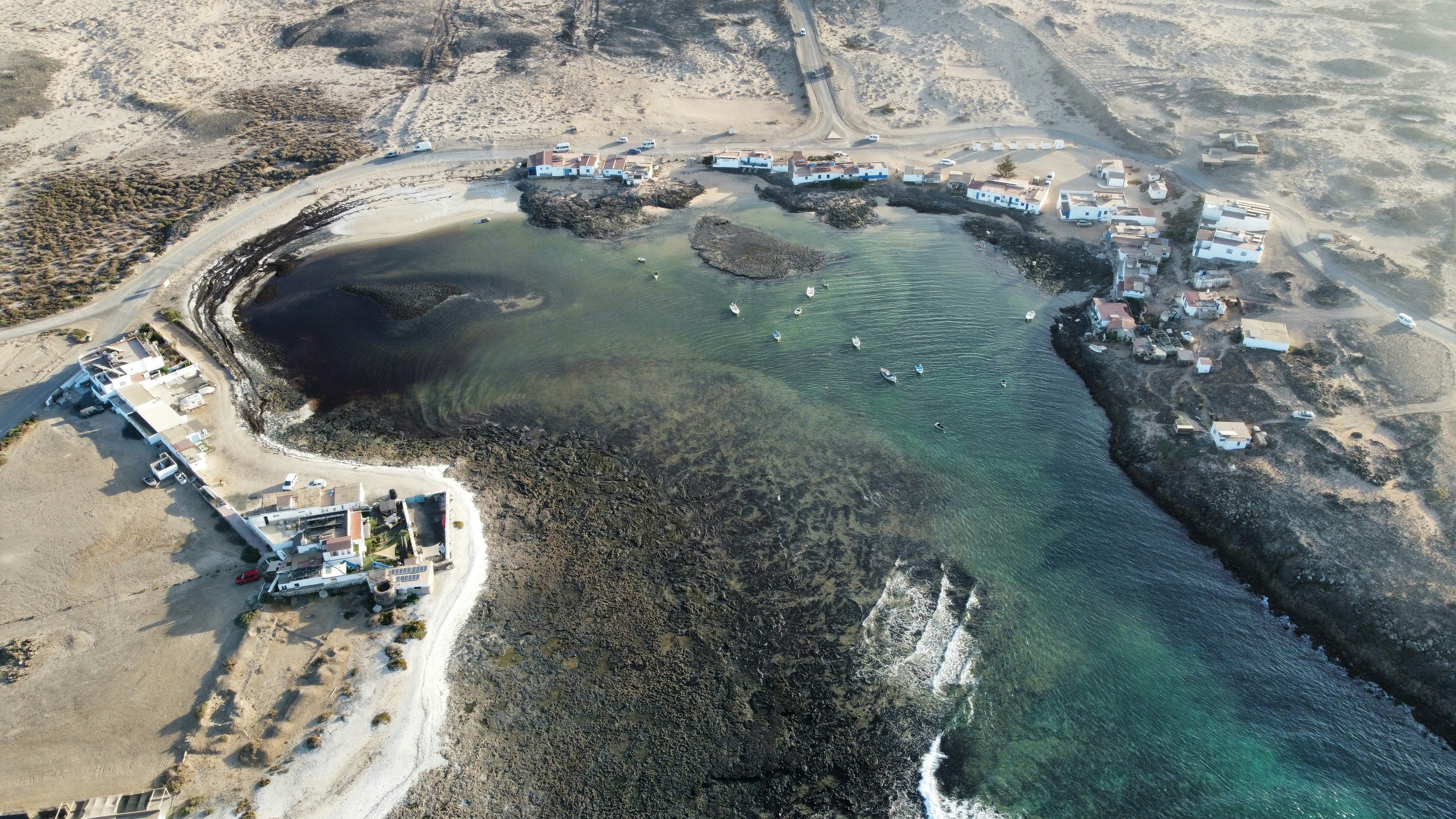 Aerial view of a coastal village with boats in bay