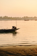 Fisherman on a boat at sunrise on the river.