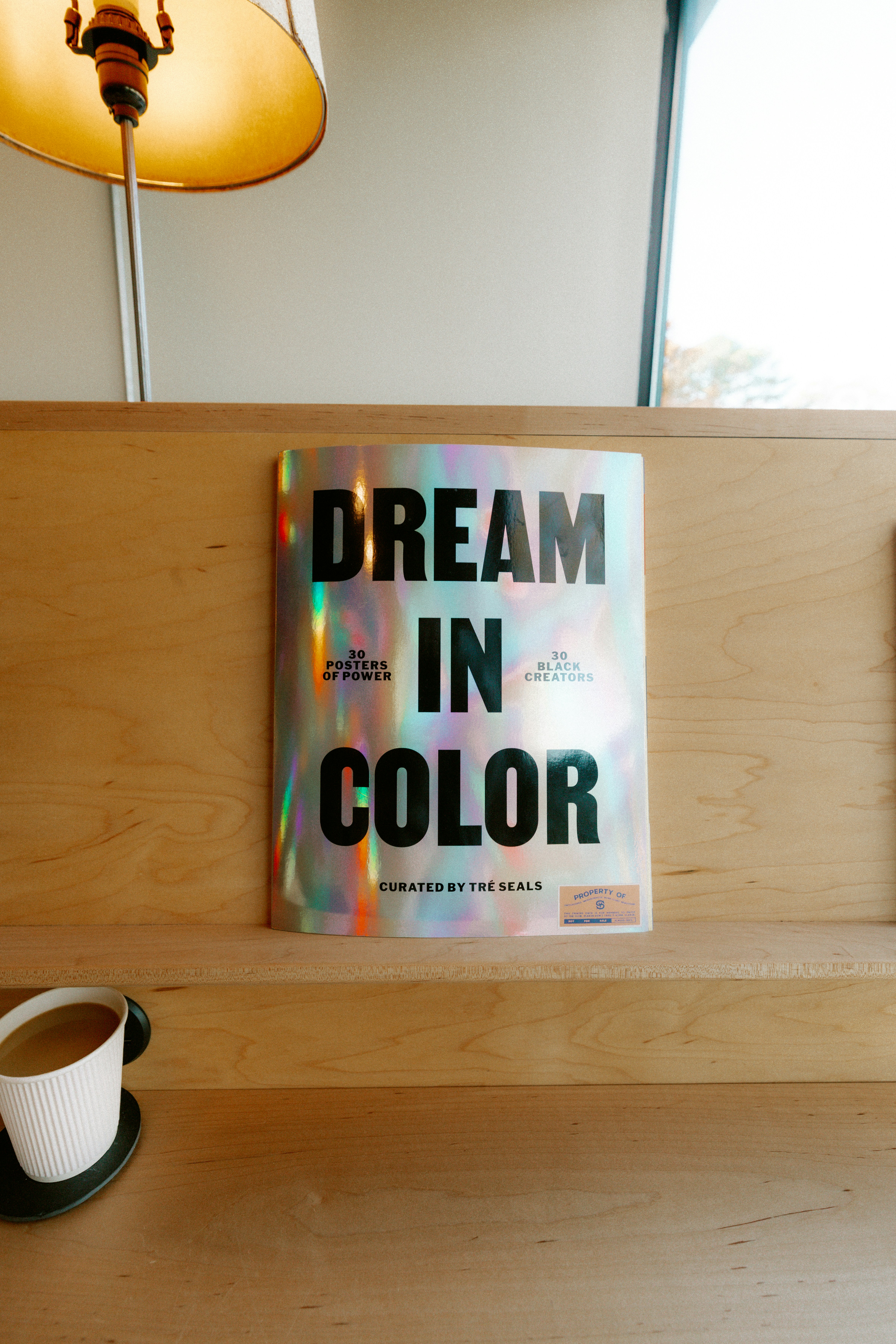 A book titled dream in color on a wooden shelf.