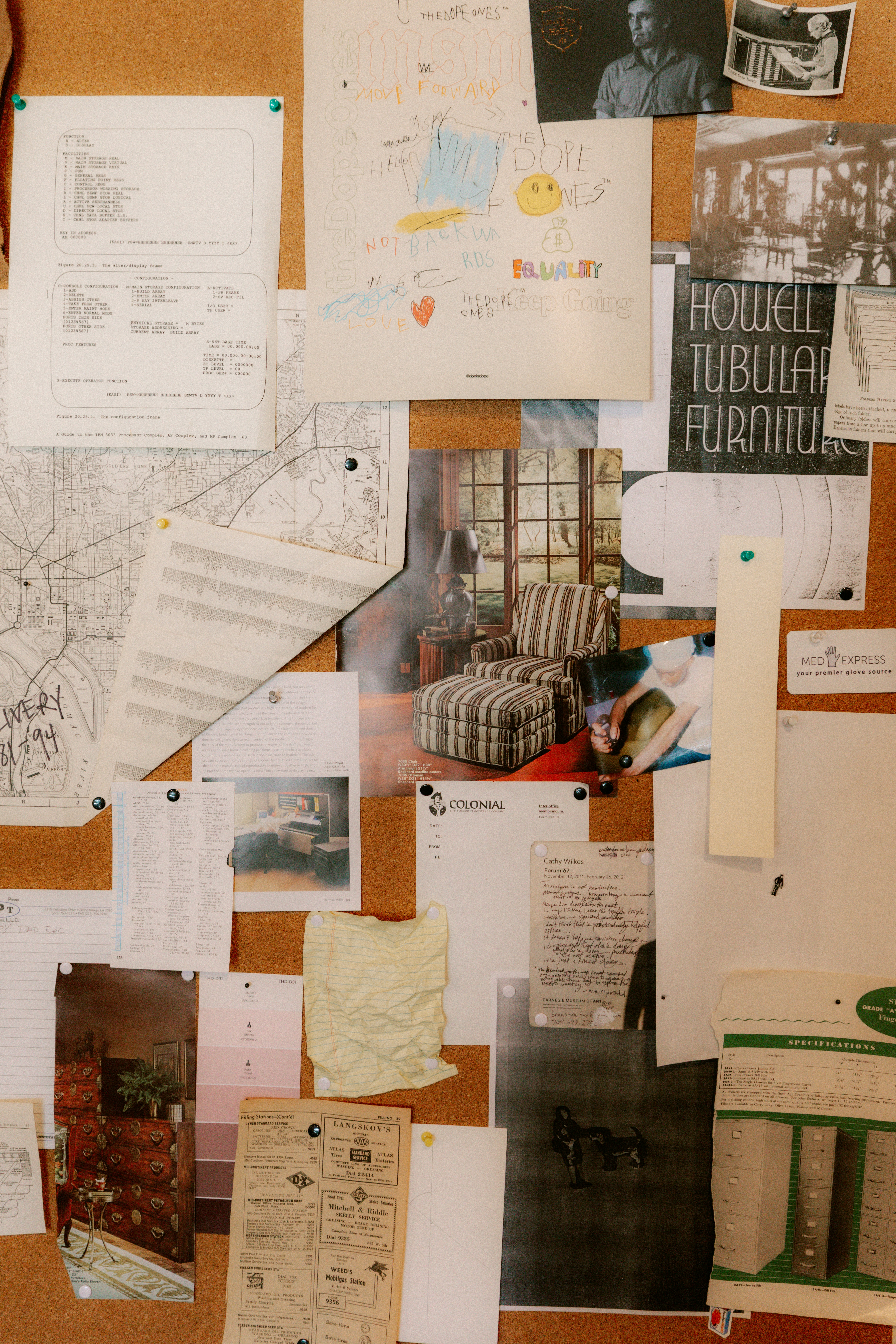 A bulletin board covered with various papers and photos.